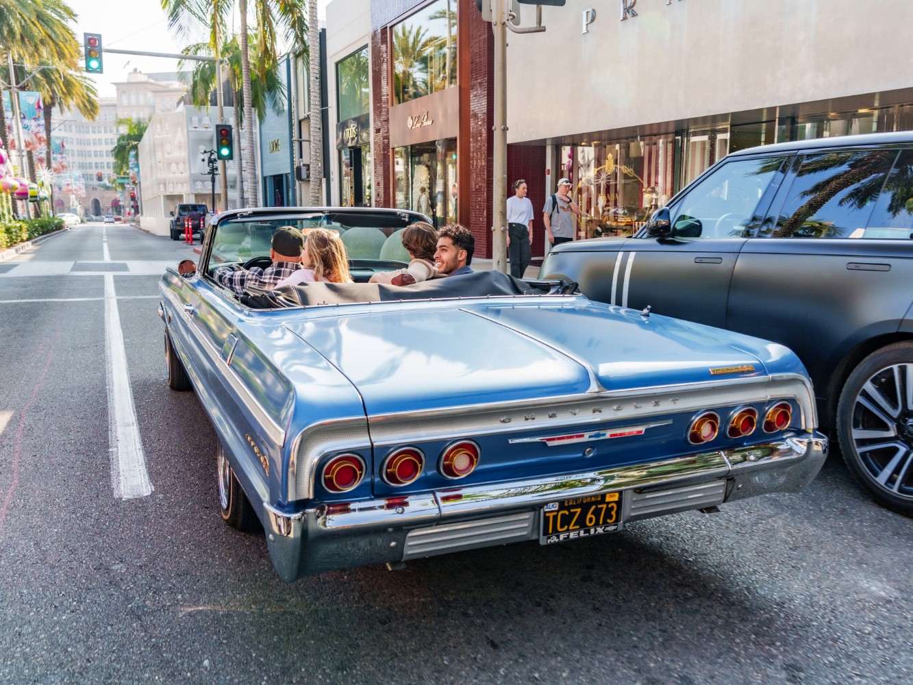 Tourists admiring intricate lowrider paint jobs and chrome details up close