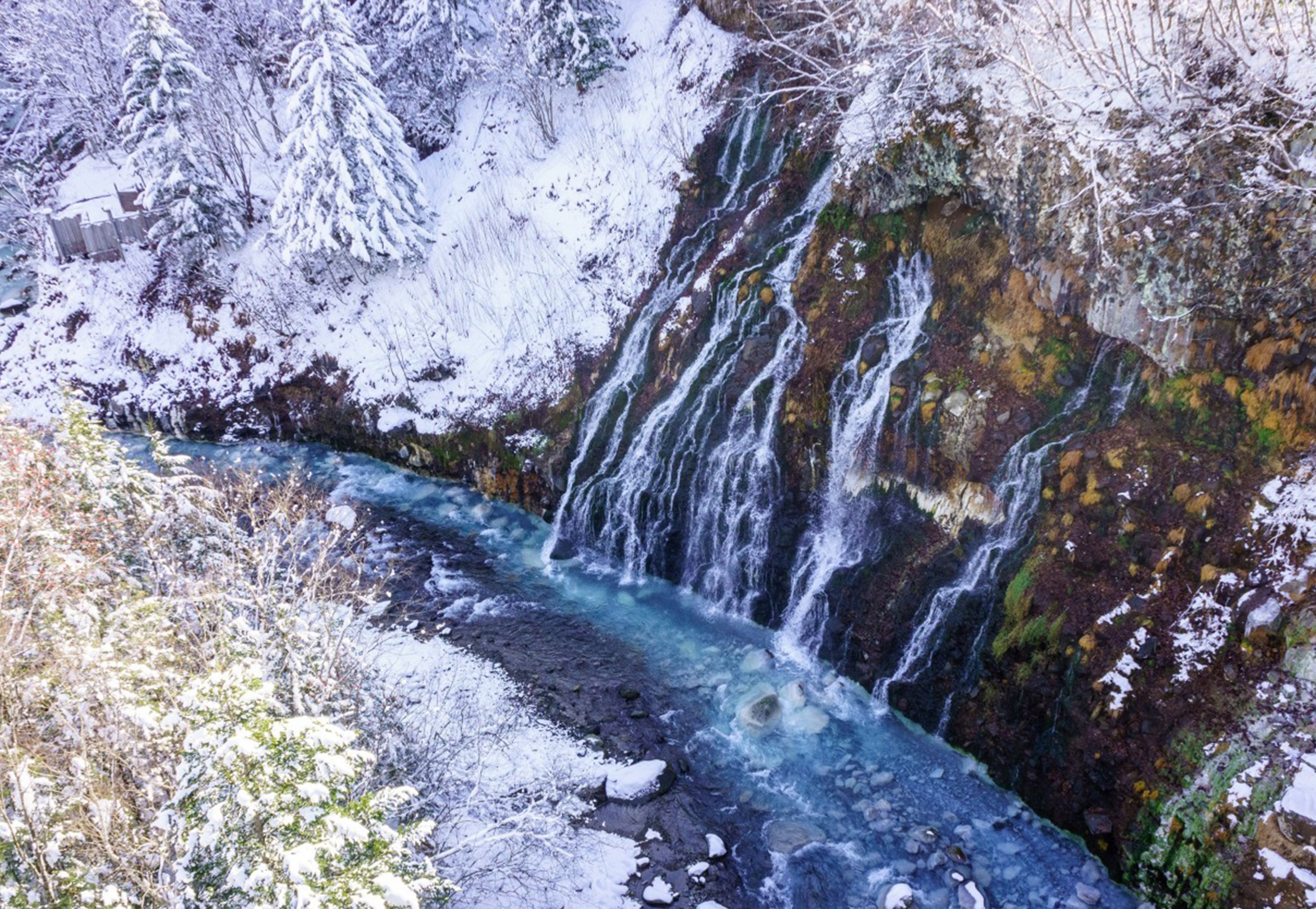 白鬚瀑布春季：積雪消融，水量充沛，兩岸新綠初綻，藍河與嫩青相映