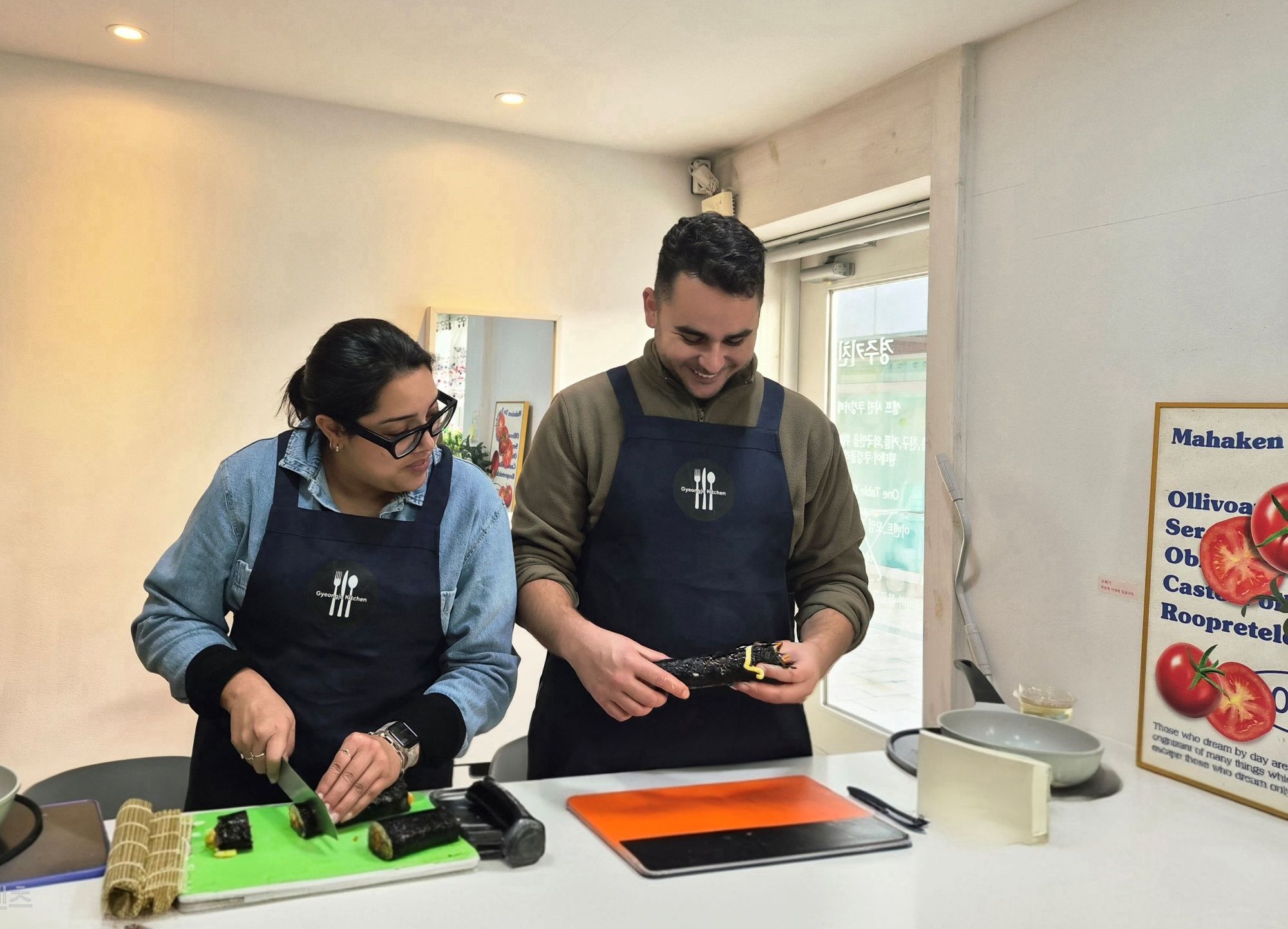 客人們在慶州廚房溫馨友好的氛圍中，一同享受親手製作紫菜包飯的課程，切片並卷制他們的作品。