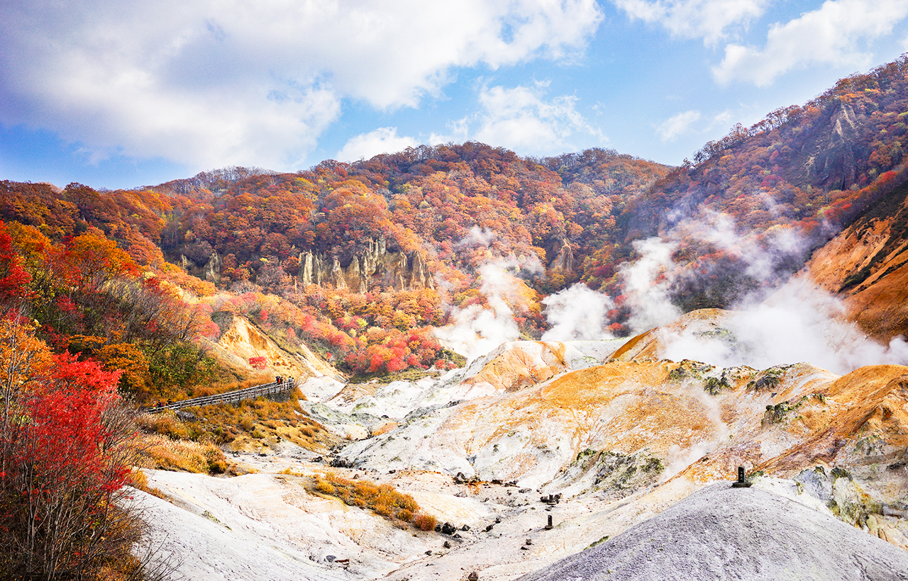 登別地獄谷是北海道著名的火山地熱景區，群山環抱中硫磺蒸氣嫋嫋升起，景象壯觀。