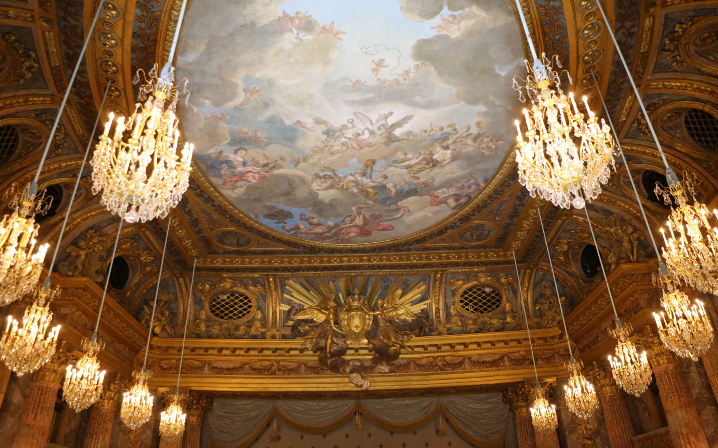 Lavish chandeliers illuminating the opulent interiors of the Palace of Versailles