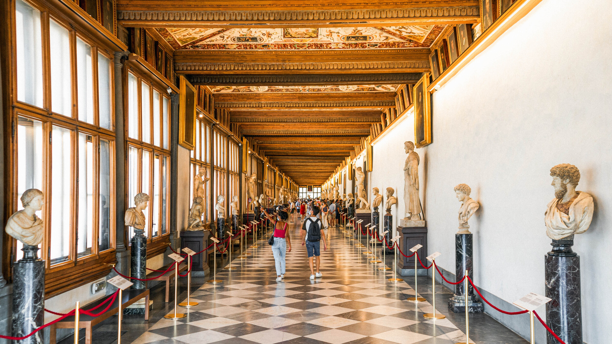 漫步於烏菲茲美術館長廊，欣賞兩旁林立的雕像，俯瞰佛羅倫斯美景。
