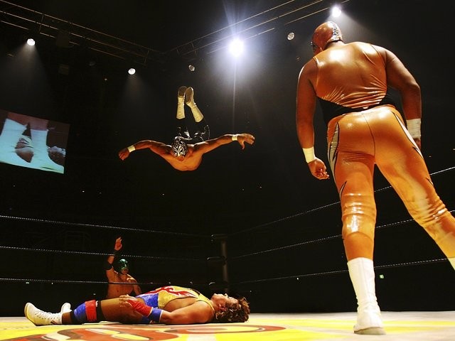 高空特技捕捉到半空中翻轉的瞬間，身體彎曲，越過一位驚呆了的、站在地面的挑戰者