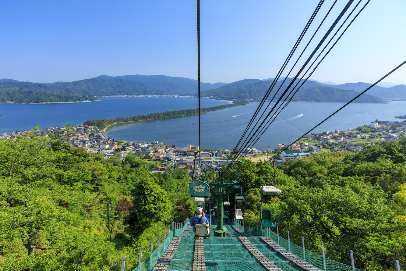 天橋立纜車是前往觀景臺欣賞全景的最佳方式之一。搭乘纜車緩緩上行，只需數分鐘便可抵達傘松公園或天橋立ビューランド。隨著高度逐漸升高，宮津灣與細長沙洲的景色在眼前徐徐展開，視野開闊壯麗。抵達山頂後，可從高處俯瞰天橋立如飛龍般橫臥海面，感受日本三景之一的震撼美景，是來訪不可錯過的體驗。