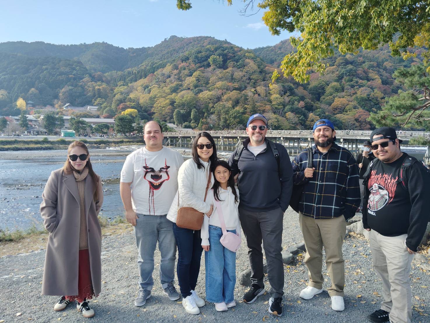 旅客們在嵐山渡月橋前合影留念,笑容洋溢於秋日山川之間,記錄京都最溫馨的瞬間。 旅客們在嵐山渡月橋前合影留念,笑容洋溢於秋日山川之間,記錄京都最溫馨的瞬間。