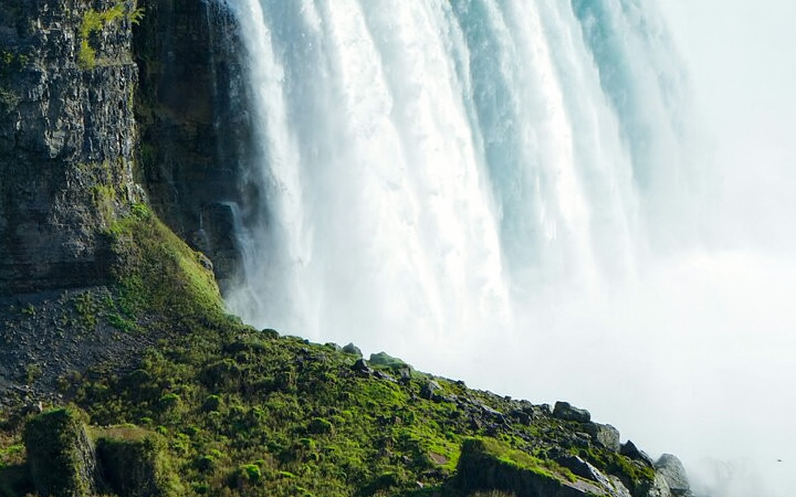 近距離感受令人驚嘆的瀑布，周圍環繞著鬱鬱蔥蔥的綠意，上方則有水霧飛濺而下。