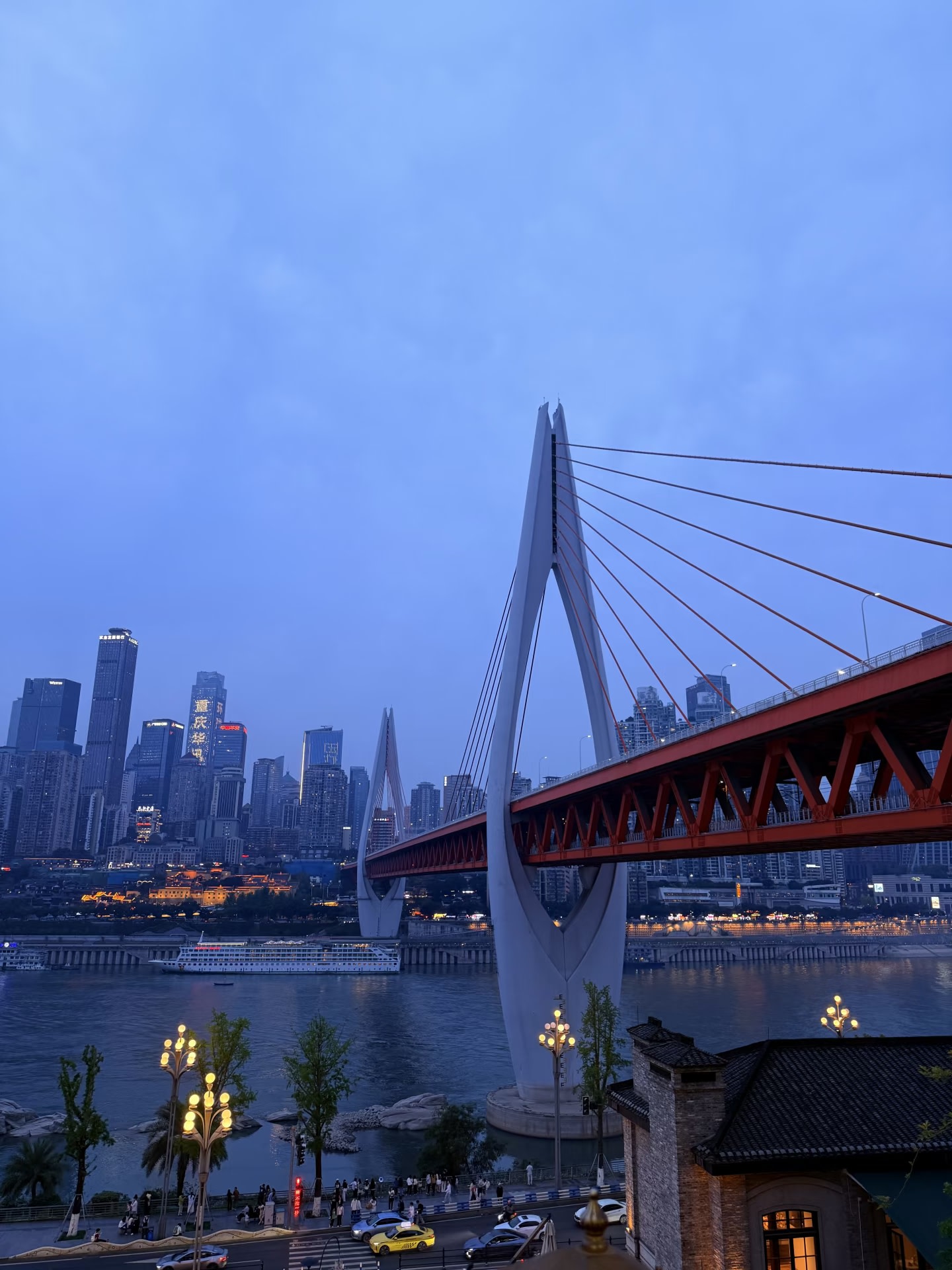 大橋暮色全景，江風拂面間，渝中半島燈火初上，山城夜景氛圍感拉滿