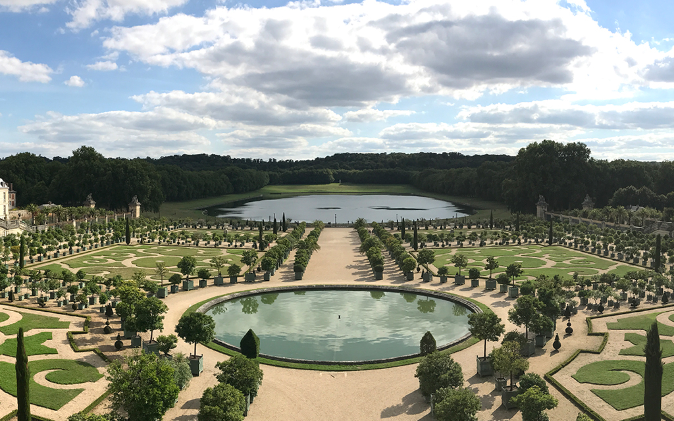 Symmetrical pathways through Versailles gardens lined with sculpted hedges