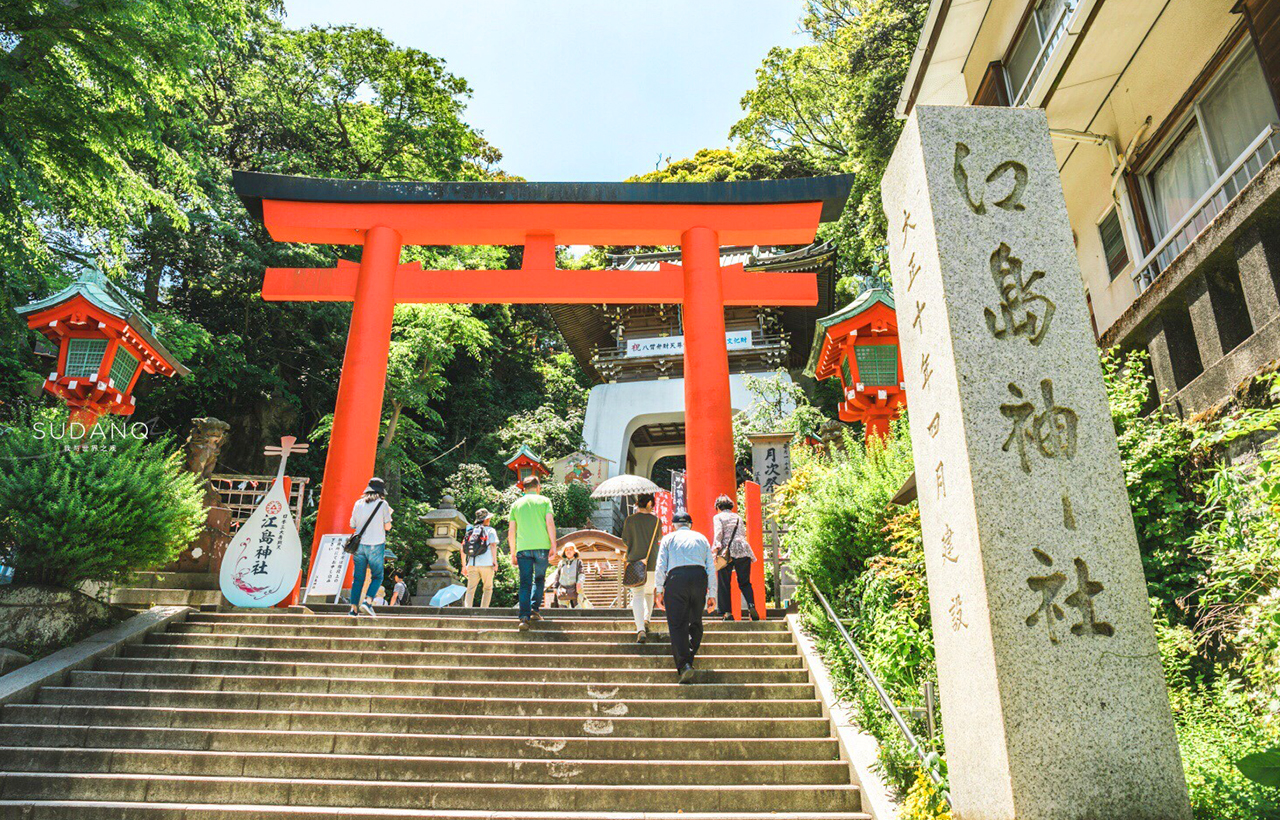 硃紅鳥居矗立石階之上,綠蔭環繞,遊人拾級而上,江島神社莊重清幽,洋溢海島神聖氣息 硃紅鳥居矗立石階之上,綠蔭環繞,遊人拾級而上,江島神社莊重清幽,洋溢海島神聖氣息