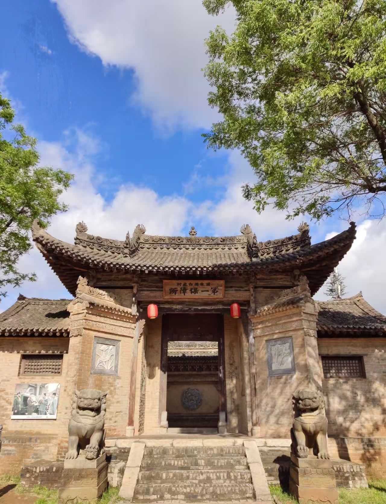 中式古建門樓,雕花精緻,石獅鎮守,匾額、紅燈籠增添傳統韻味,藍天綠樹映襯,盡顯關中民居的古樸莊重,是影視城歷史文化氛圍的縮影 中式古建門樓,雕花精緻,石獅鎮守,匾額、紅燈籠增添傳統韻味,藍天綠樹映襯,盡顯關中民居的古樸莊重,是影視城歷史文化氛圍的縮影