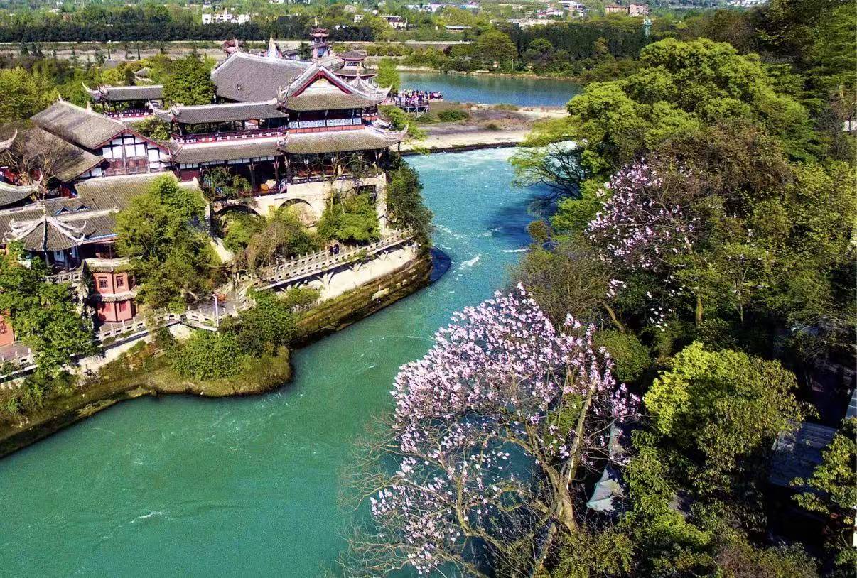 這是都江堰寶瓶口的春日航拍,江水碧綠如玉,古建飛簷翹角臨江而立,岸邊粉花盛放,與蔥鬱林木相映,盡顯川西水利古景的靈秀生機 這是都江堰寶瓶口的春日航拍,江水碧綠如玉,古建飛簷翹角臨江而立,岸邊粉花盛放,與蔥鬱林木相映,盡顯川西水利古景的靈秀生機