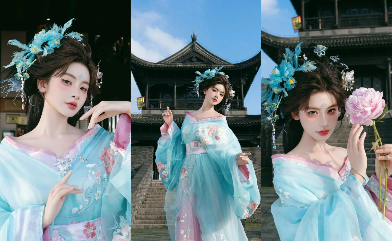 人物頭上佩戴著藍色的花朵髮飾，與服裝相呼應，整體造型精美，背景是一座古色古香的中式建築，具有傳統建築的韻味