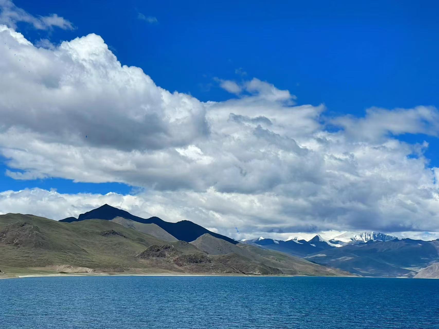 澄澈湛藍的羊卓雍措鋪展大地,厚重白雲鋪滿澄澈藍天。近處湖水泛著細密波紋,沿岸是緩坡草山,遠處雪山連綿隱於雲層,天地開闊靜謐,盡顯高原聖湖純淨遼闊的治癒風光 澄澈湛藍的羊卓雍措鋪展大地,厚重白雲鋪滿澄澈藍天。近處湖水泛著細密波紋,沿岸是緩坡草山,遠處雪山連綿隱於雲層,天地開闊靜謐,盡顯高原聖湖純淨遼闊的治癒風光