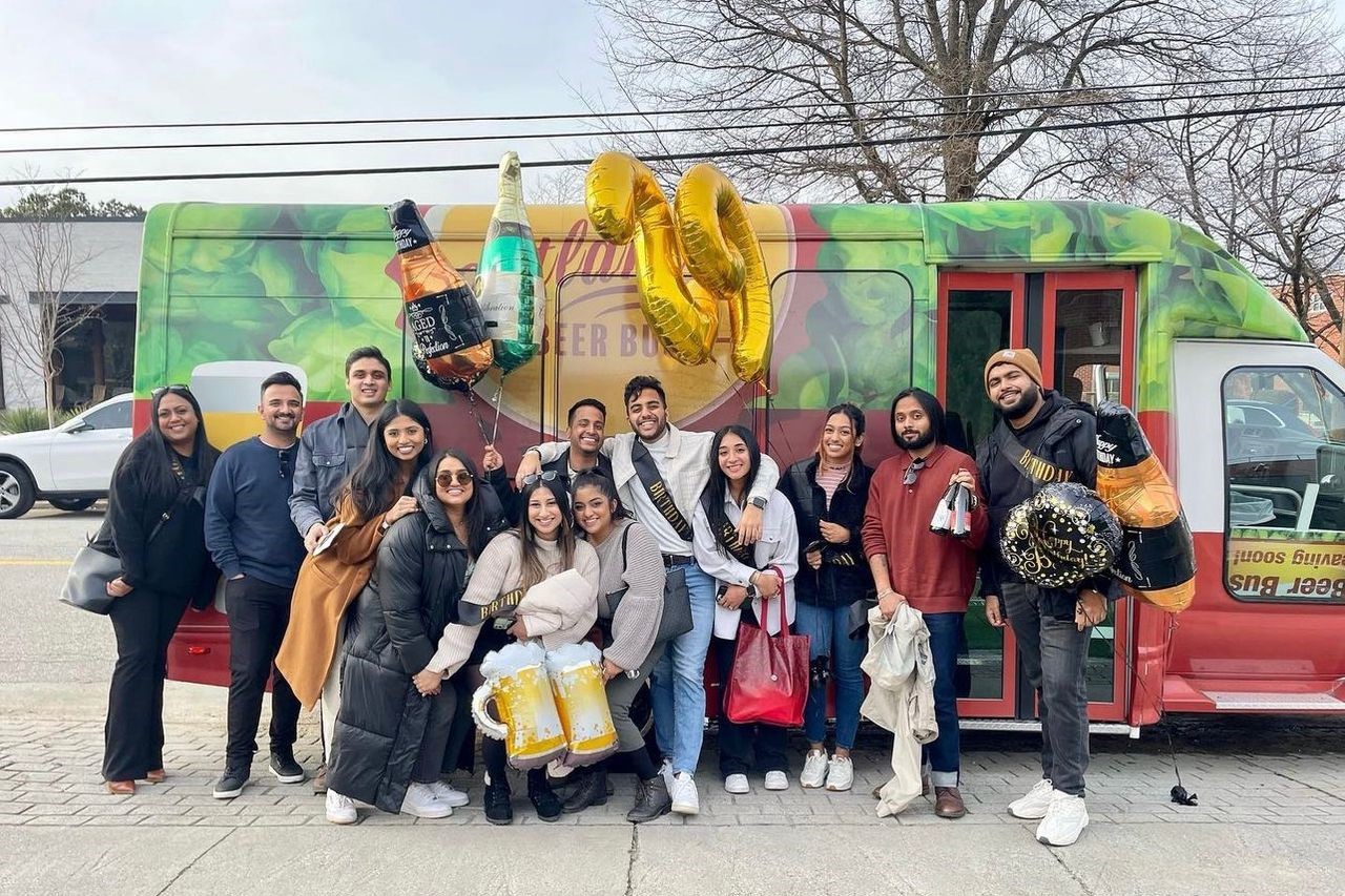 一群興奮的人群站在一輛色彩鮮豔的巴士前，準備迎接即將到來的冒險