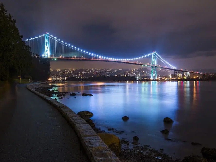 Capture Vancouver's nighttime magic with illuminated Lions Gate Bridge and bustling city energy.