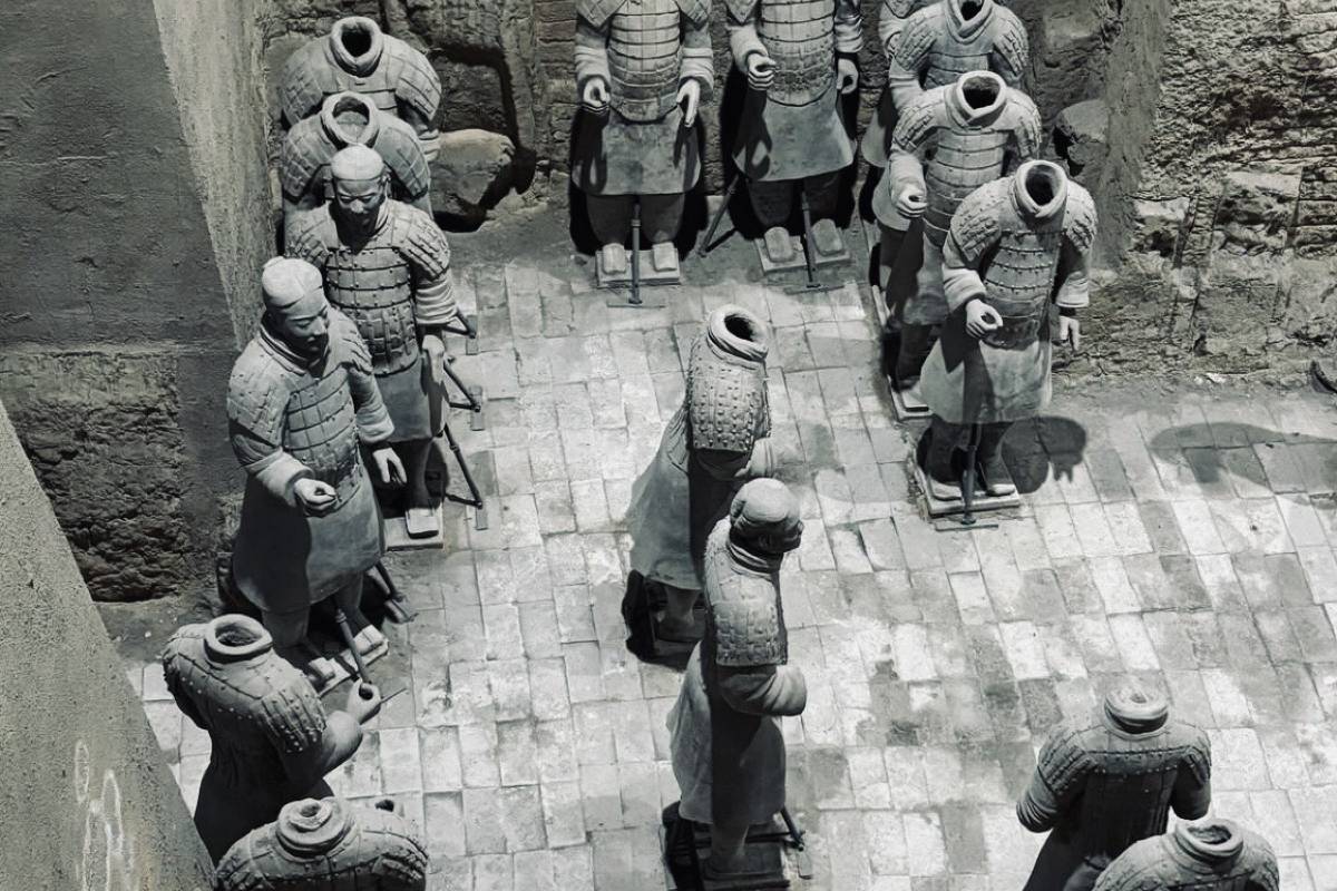 秦始皇兵馬俑博物館，在世界考古領域熠熠生輝，是當之無愧的最偉大考古遺址之一，更是閃耀於20世紀的偉大發現。這座博物館由三大俑坑與一座展廳構成，它們宛如時光寶盒，收納著一段波瀾壯闊的歷史。8000尊真人大小的兵馬俑震撼入目，每一尊都栩栩如生，神情各異。他們整齊列陣，按照真實作戰陣型嚴陣以待，長矛林立、鎧甲鮮明，似在無聲訴說著秦軍“橫掃六國，虎視何雄哉”的霸氣。兩千二百多年的漫長歲月裡，這些兵馬俑靜靜沉睡地下，直至1974年才重見天日，它們承載著厚重歷史，一朝現世，便驚豔世界，成為中華文明不朽的瑰寶 。