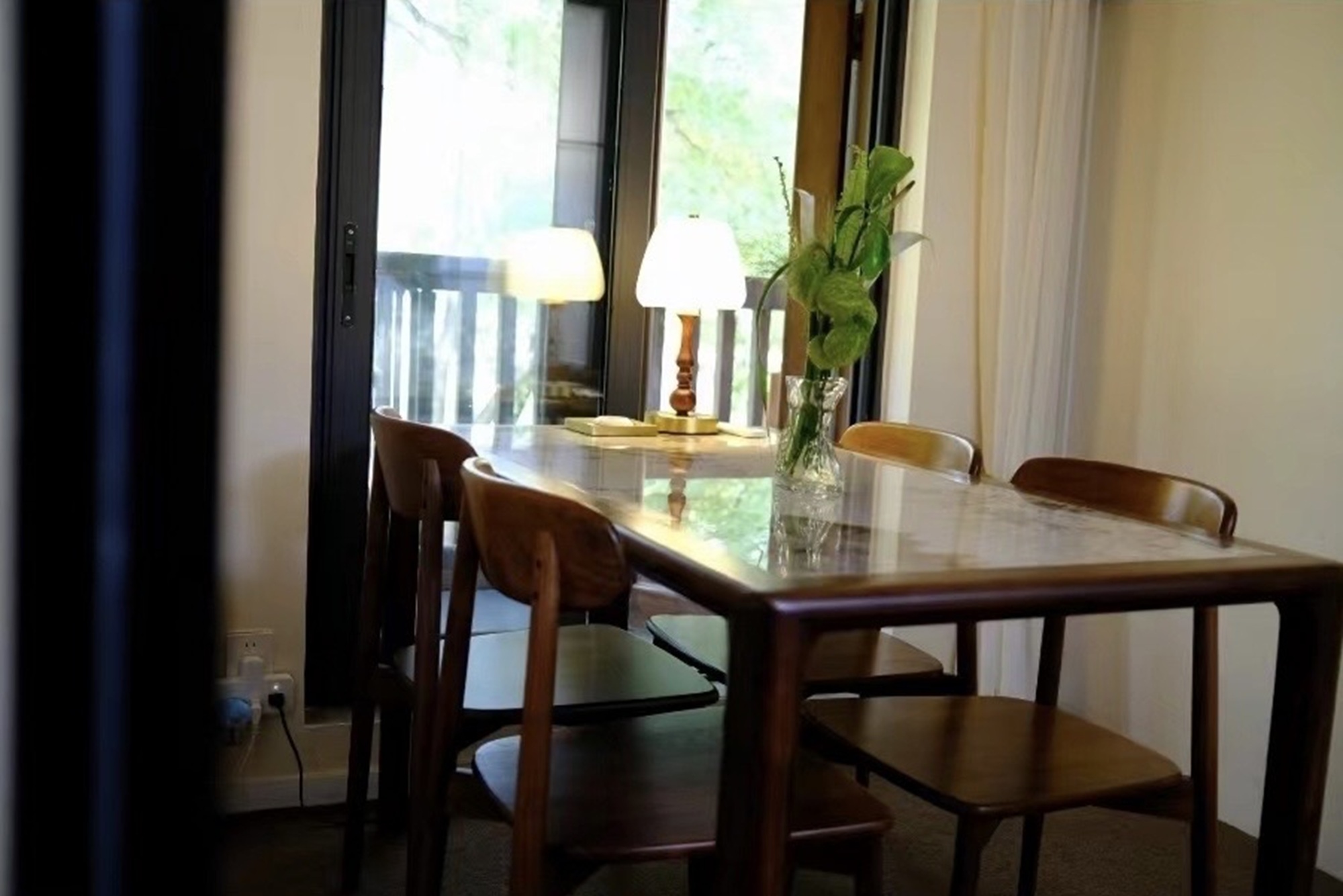 茶舍室內一角，木桌配燈與綠植，光線柔和，氛圍溫馨舒適