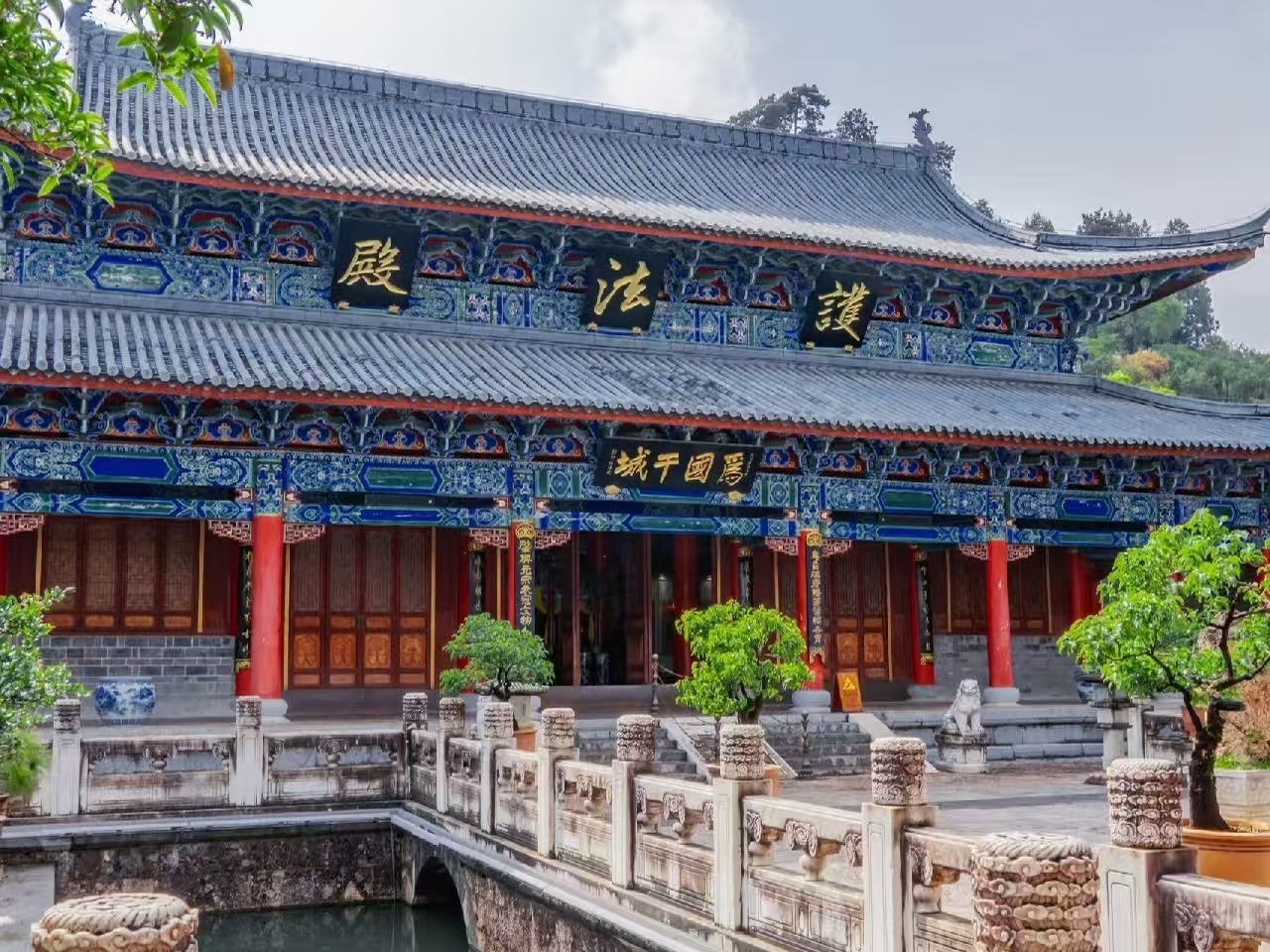 木府護法殿全景清晰呈現，雙層歇山頂的藍彩彩繪精美繁複，“護法殿” 金匾熠熠生輝