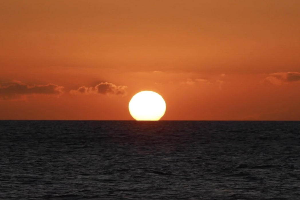 Witness a breathtaking Maui sunset, painting the sky with vibrant colors as you sail the calm ocean