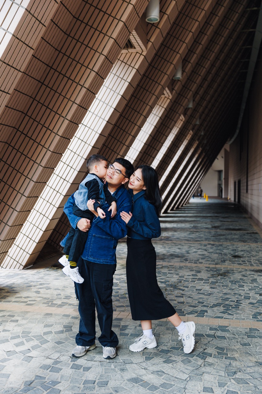 A memorable family moment with the impressive façade of the Hong Kong Cultural Centre, celebrating the essence of cultural heritage.