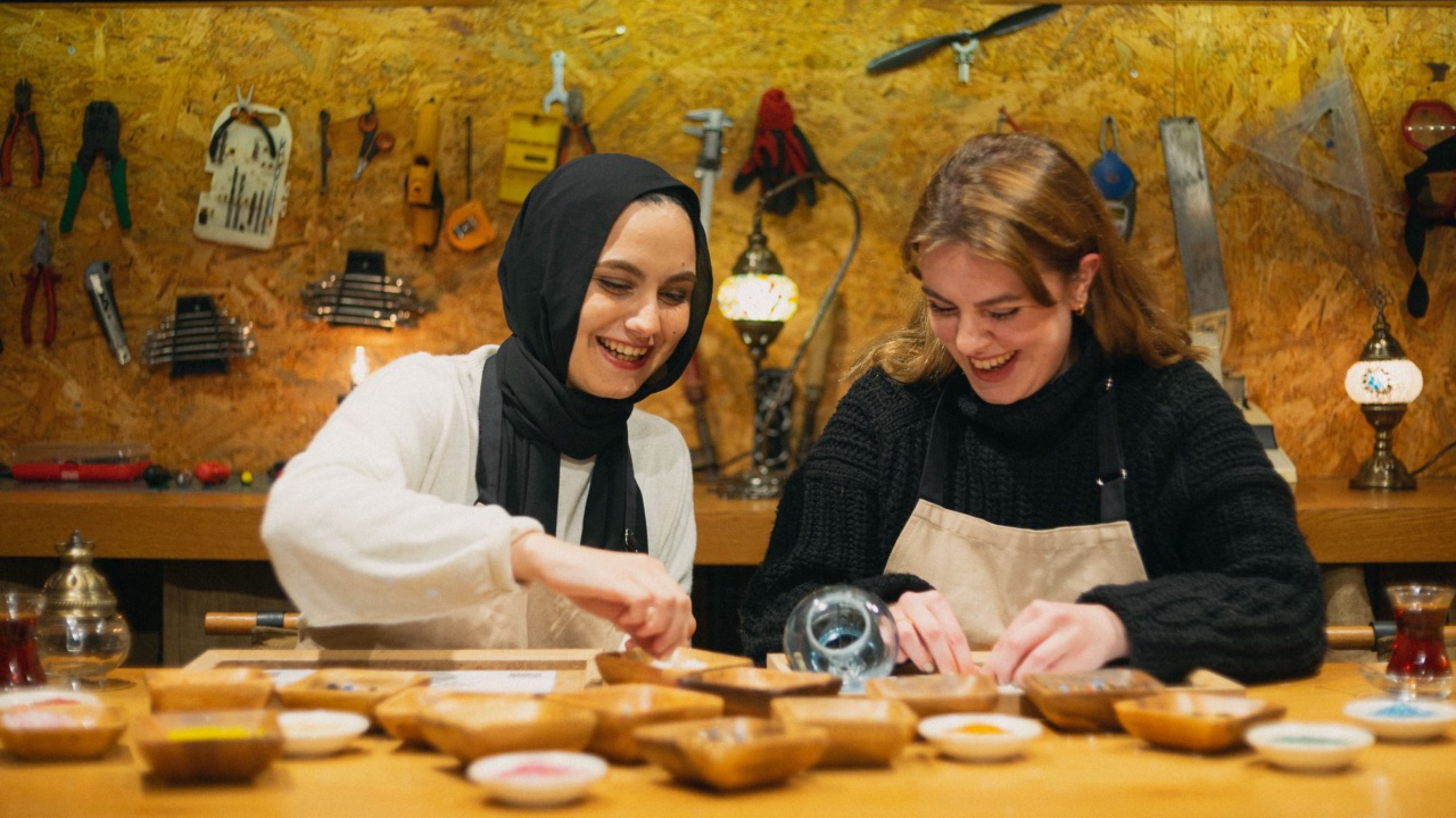 Sprinkling glass beads to complete the vibrant design of a mosaic lamp made in Istanbul