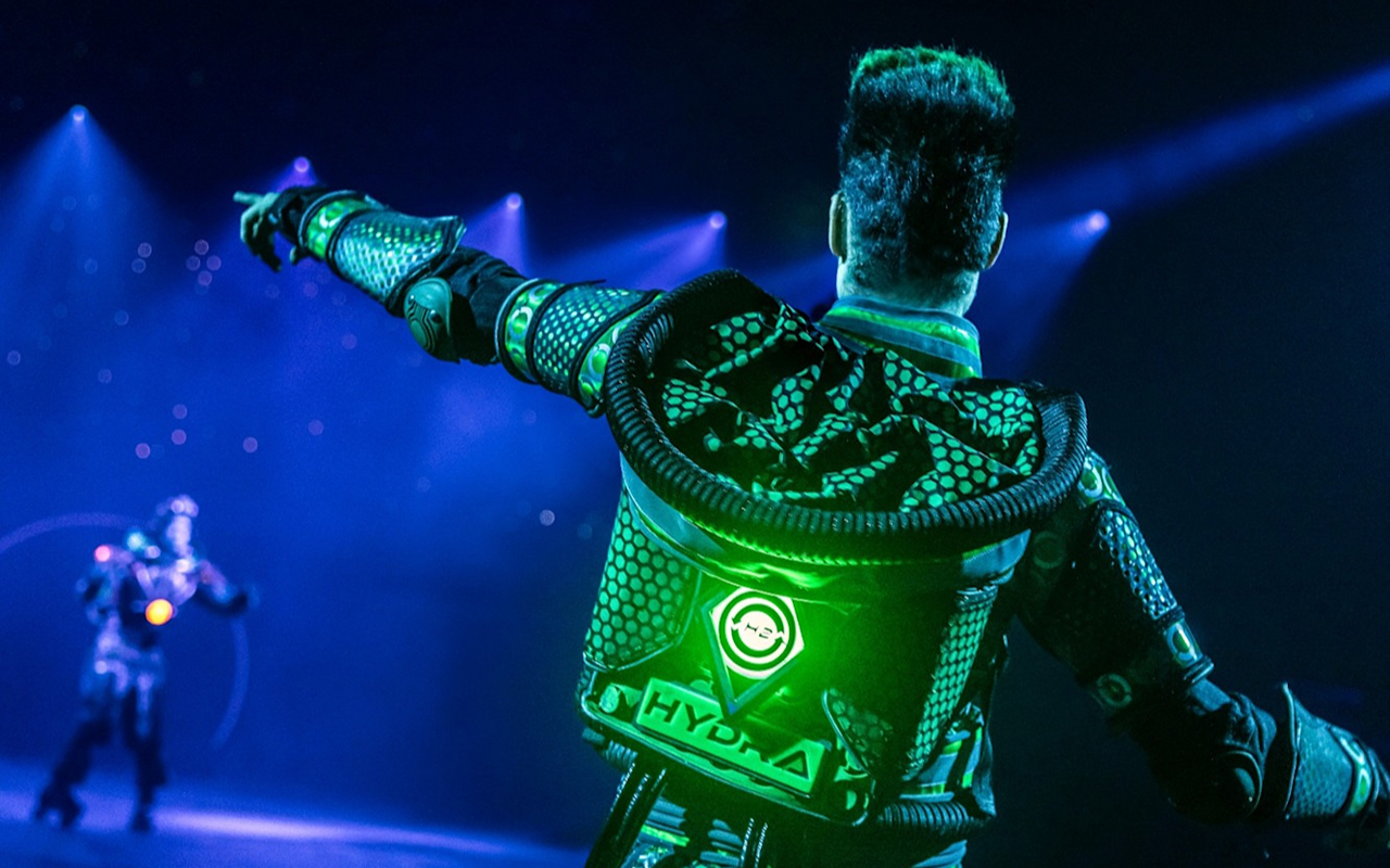 Witness the performer guiding you through an electrifying, vibrant new world