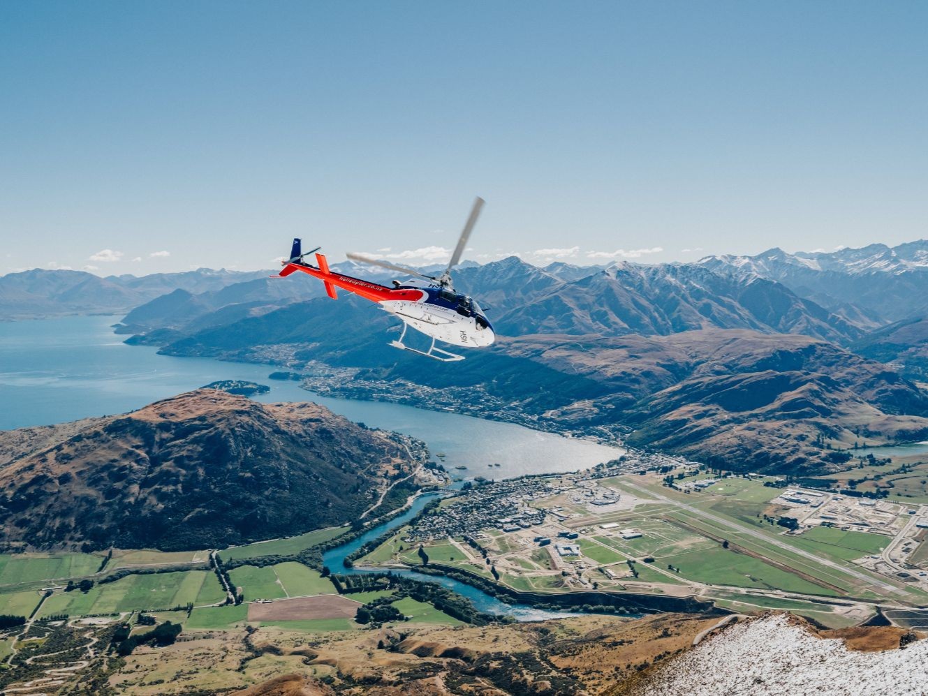 Helicopter flying past the stunning Remarkables. Helicopter flying past the stunning Remarkables.