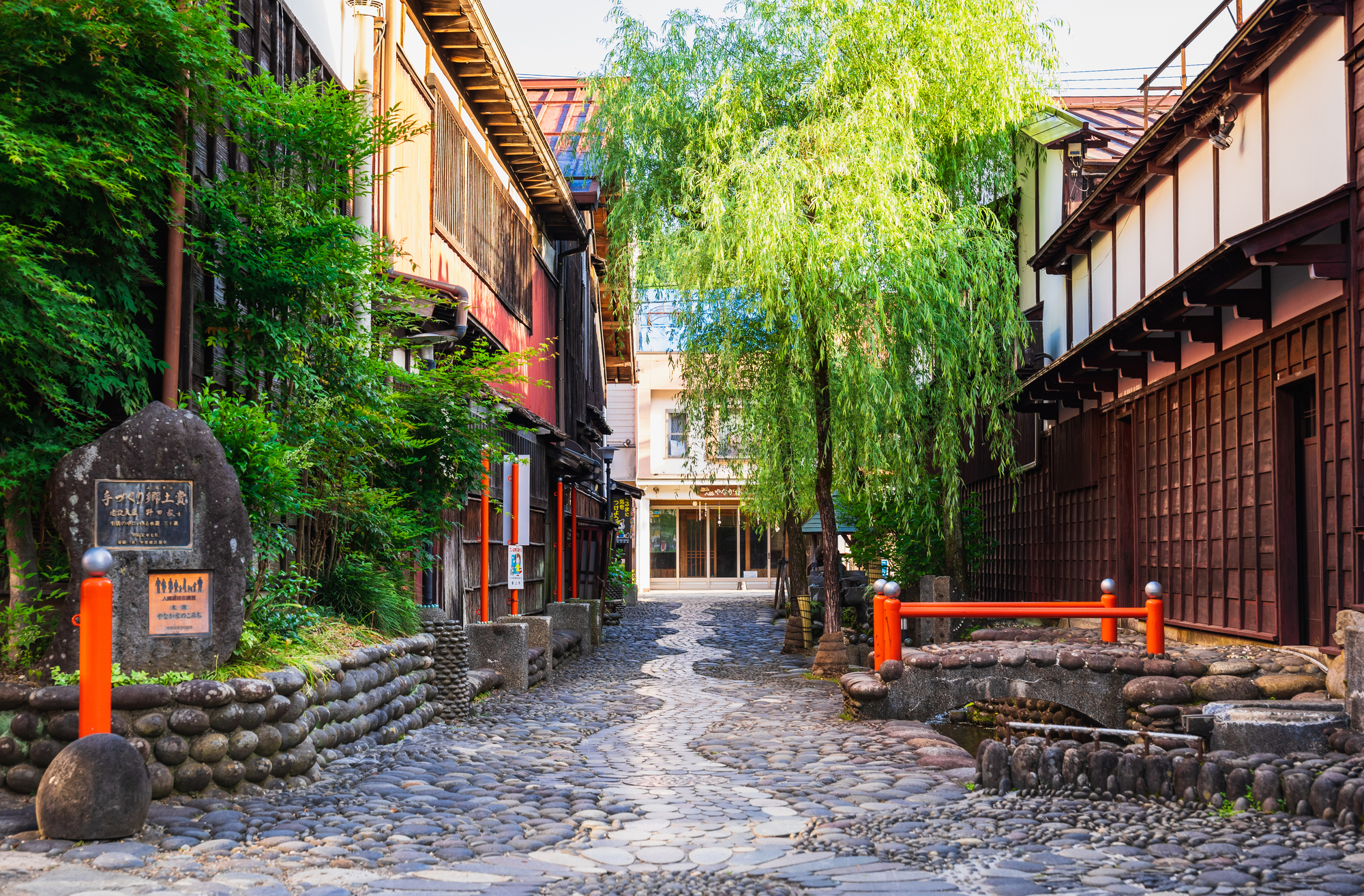 【郡上八幡 夏季】著名的清流小徑，沿途可見潺潺流水與古樸石道。這裡展現當地「水之城」的生活風景，居民日常利用清澈溪水洗菜、清潔，充滿樸實氣息。環境幽靜雅致，非常適合散步與拍照。