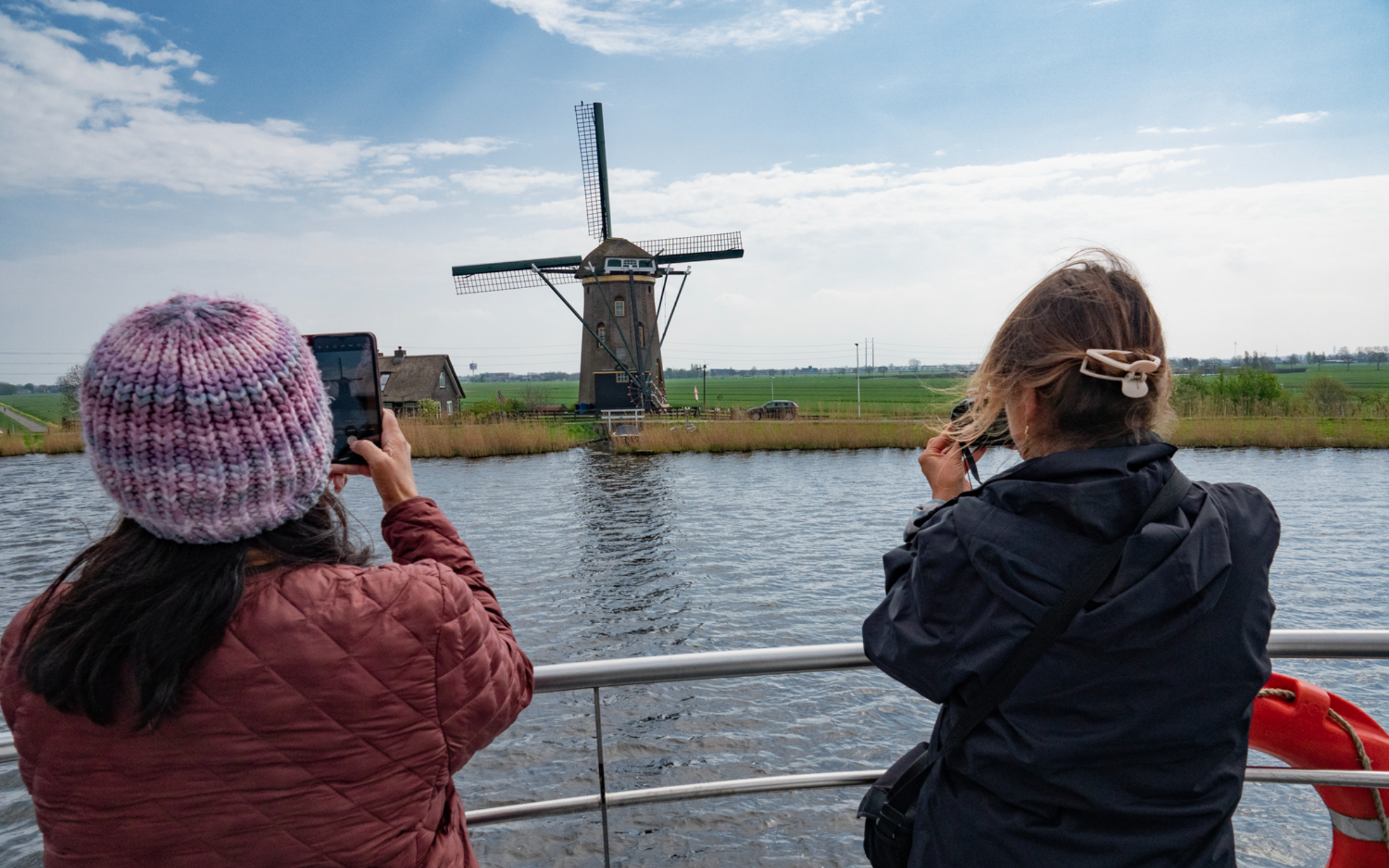 歷史悠久的風車優雅地倒映在靜止閃爍的運河水中 歷史悠久的風車優雅地倒映在靜止閃爍的運河水中