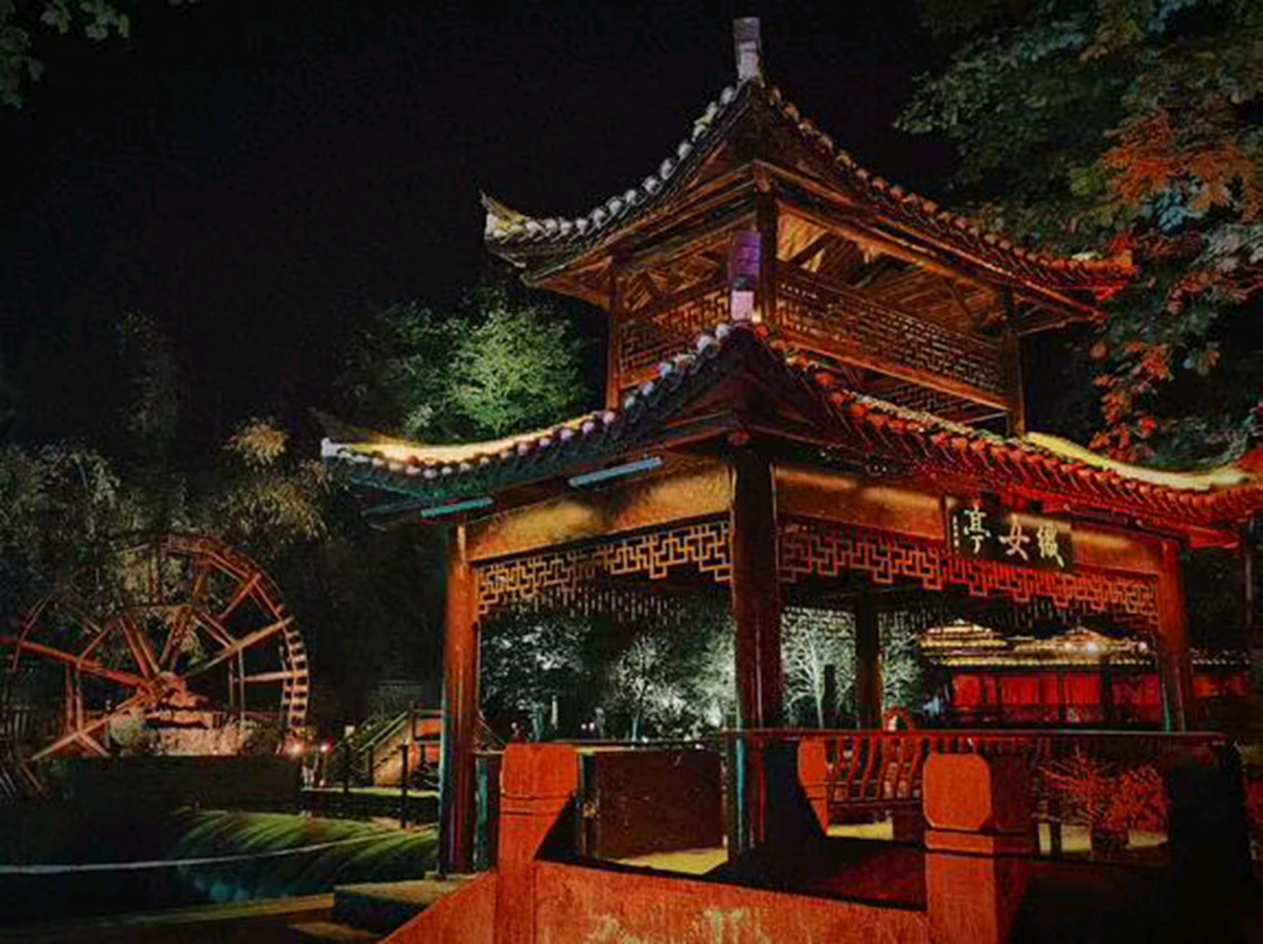 夜色裡，一座雙層古亭被暖光與霓虹點亮，飛簷翹角在黑夜裡格外醒目