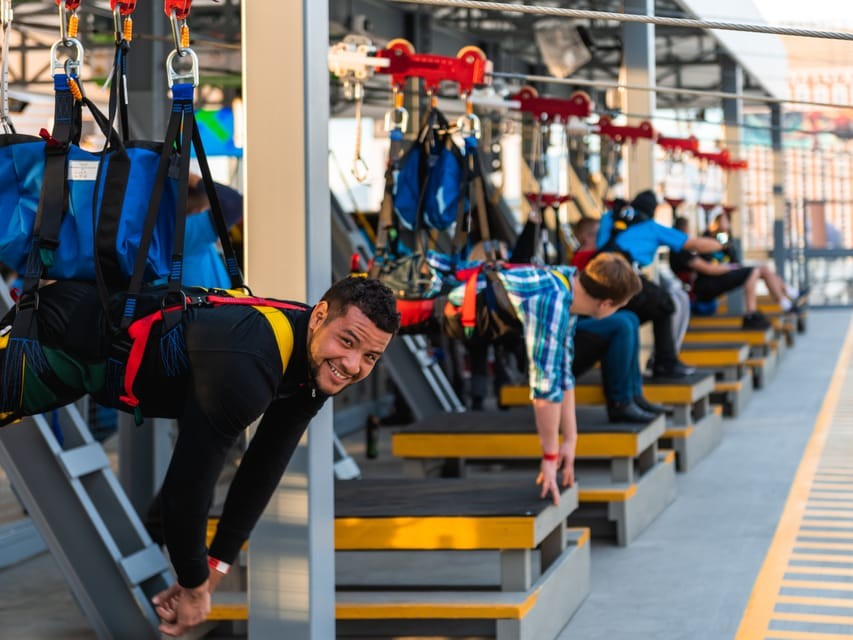 Group of riders launching from the tall zipline platform with excited expressions