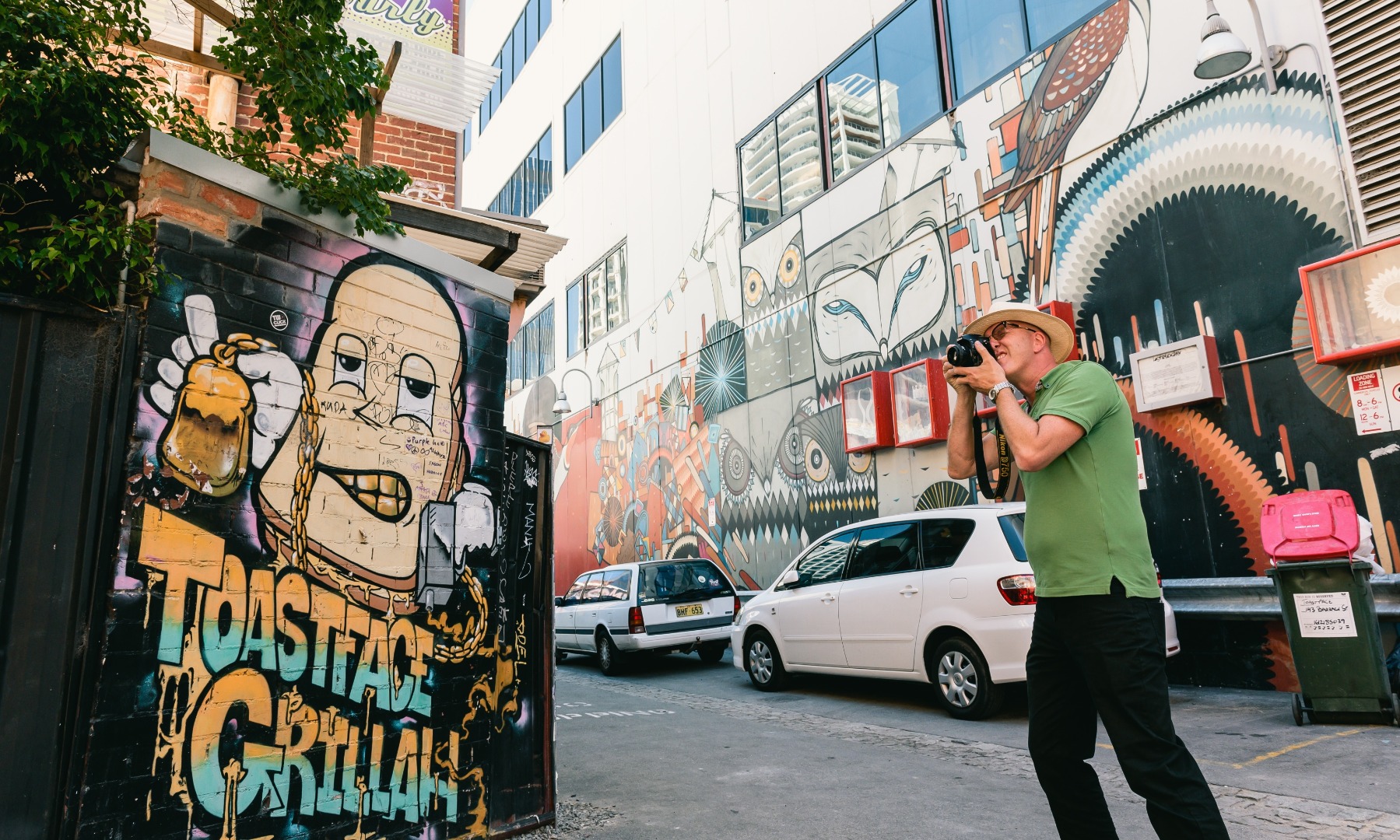 man photographing street art