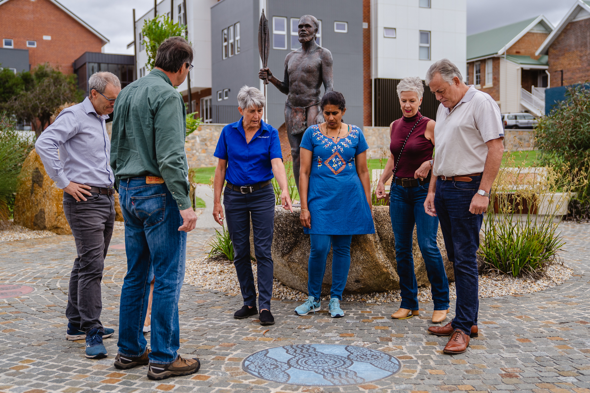 導遊正向旅遊團成員們指著人行道