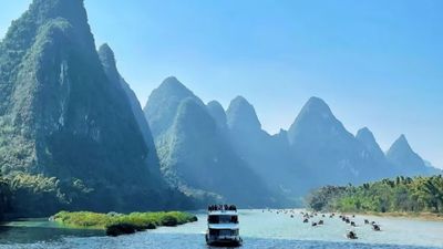 三星遊船平穩航行於灕江之上，兩岸群峰疊翠、雲霧輕籠，船行景移，盡覽水墨山水精華