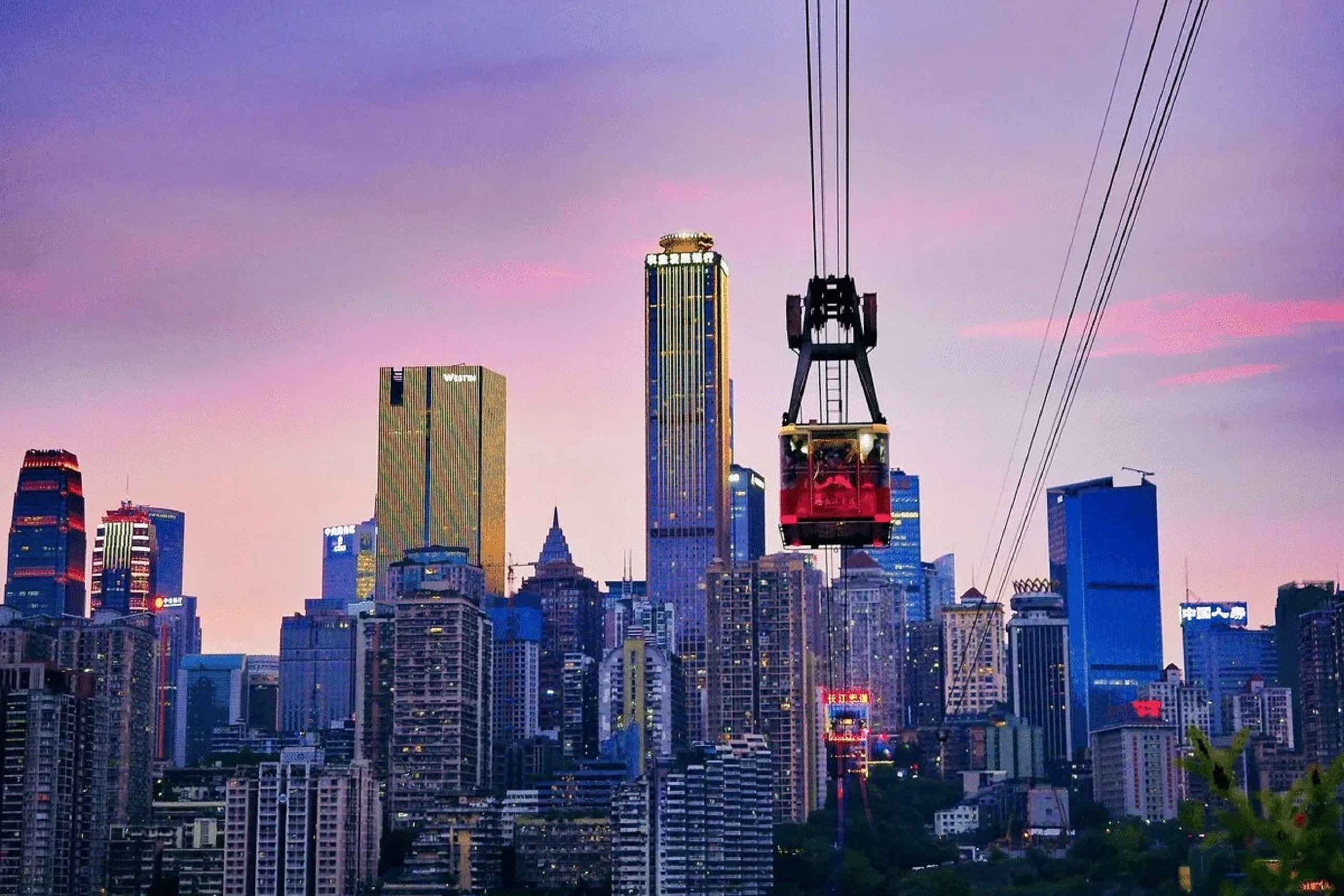 黃昏下的長江索道，飛越山城天際線！粉紫晚霞鋪滿天空，纜車穿梭於摩天樓宇間，把重慶的浪漫與繁華盡收眼底，氛圍感直接拉滿