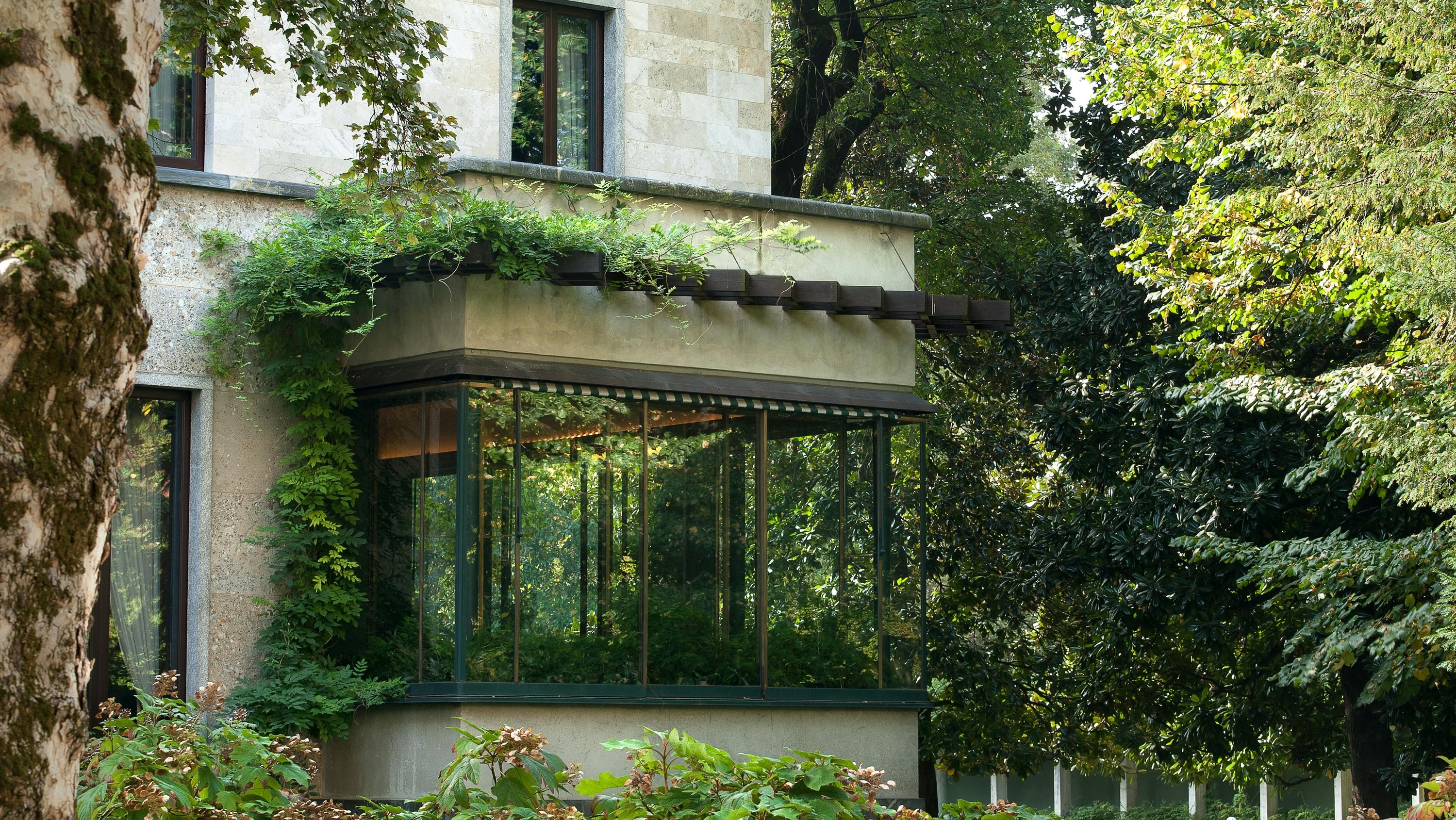 Admire the villa's seamless integration of indoor and outdoor spaces, surrounded by lush greenery
