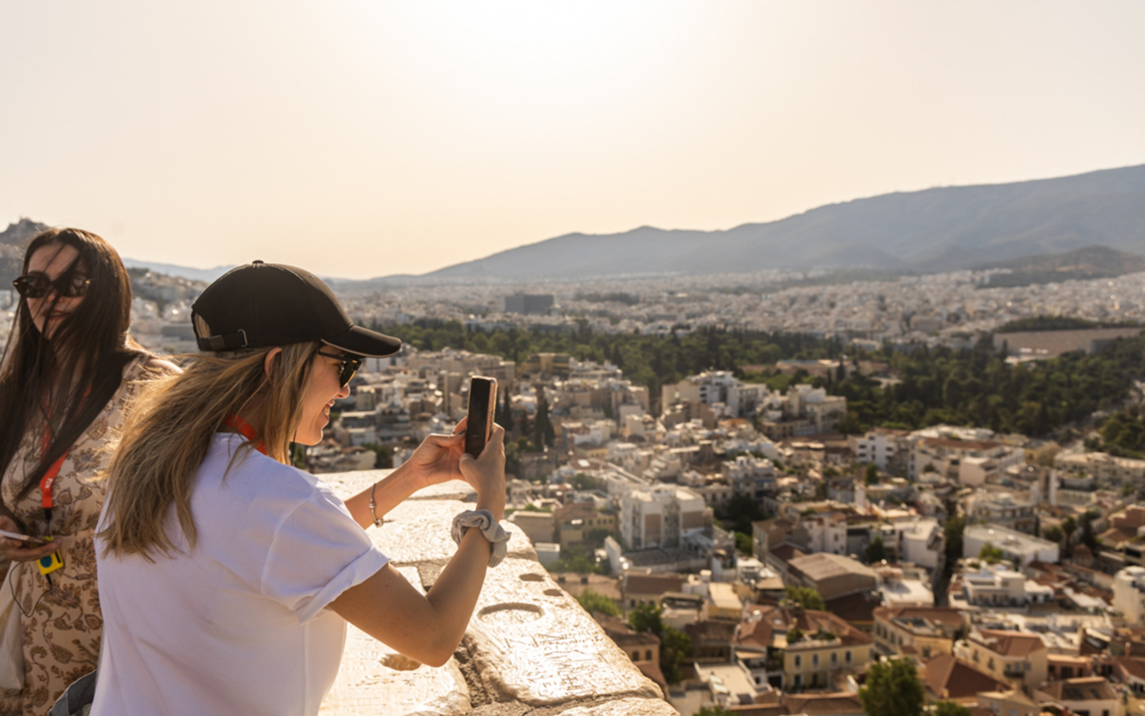 遊客從雅典衛城高處拍攝雅典廣闊的城市景觀，欣賞全景和歷史之美。