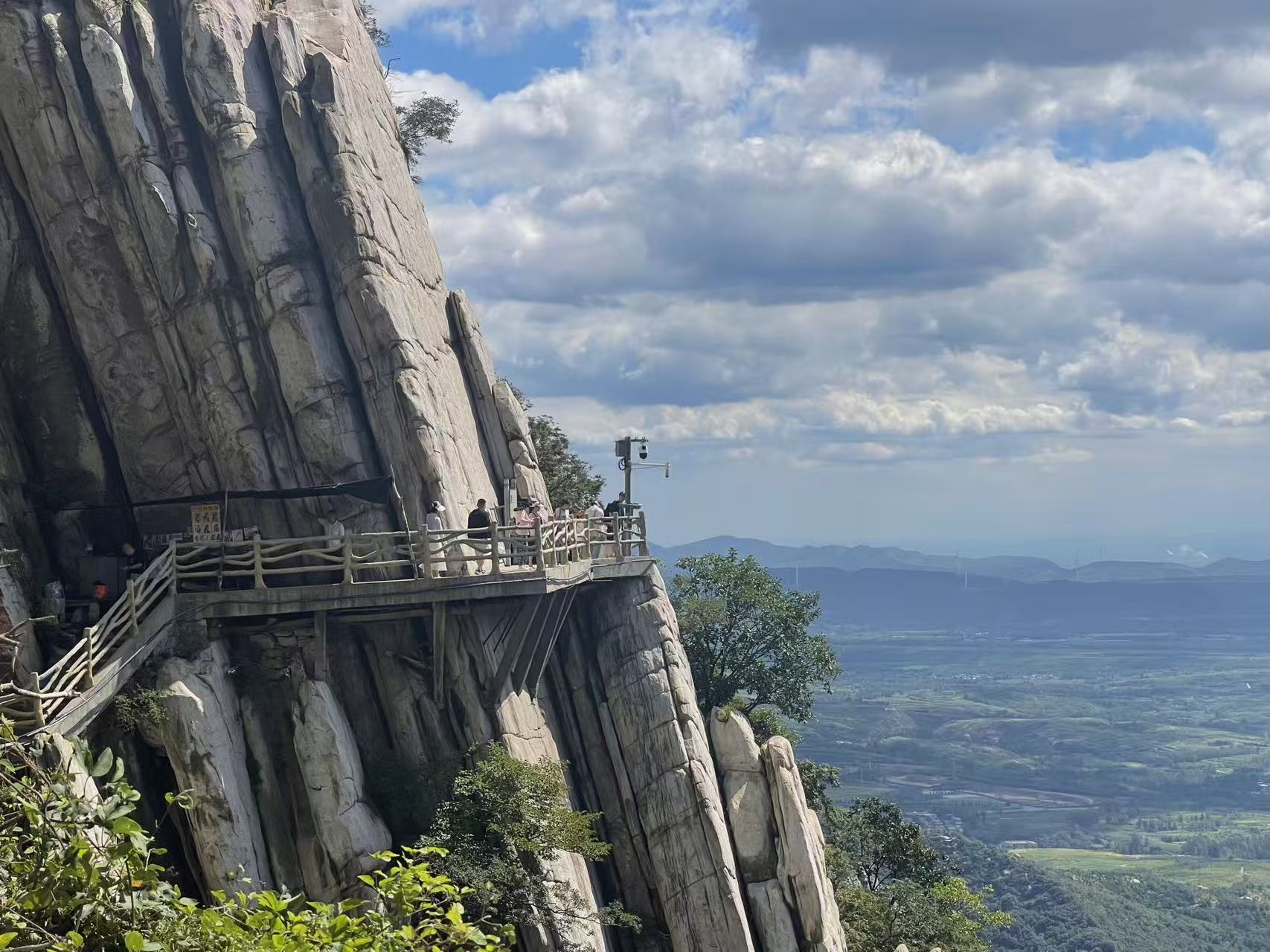 嵩山懸崖棧道:木質棧道依附在垂直的片麻岩崖壁上,遊客憑欄遠眺,腳下是開闊的中原平原,遠處山巒層疊,盡顯 “壁立千仞” 的險峻與壯美 嵩山懸崖棧道:木質棧道依附在垂直的片麻岩崖壁上,遊客憑欄遠眺,腳下是開闊的中原平原,遠處山巒層疊,盡顯 “壁立千仞” 的險峻與壯美
