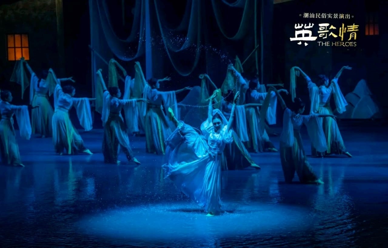 水臺之上,舞者們身著素色長裙,在藍光籠罩下翩翩起舞。靈動水袖與飛濺水花呼應,營造出空靈、柔美的氛圍,似演繹潮汕民俗裡的月夜傳說,用舞蹈詮釋本土文化的婉約意境 水臺之上,舞者們身著素色長裙,在藍光籠罩下翩翩起舞。靈動水袖與飛濺水花呼應,營造出空靈、柔美的氛圍,似演繹潮汕民俗裡的月夜傳說,用舞蹈詮釋本土文化的婉約意境