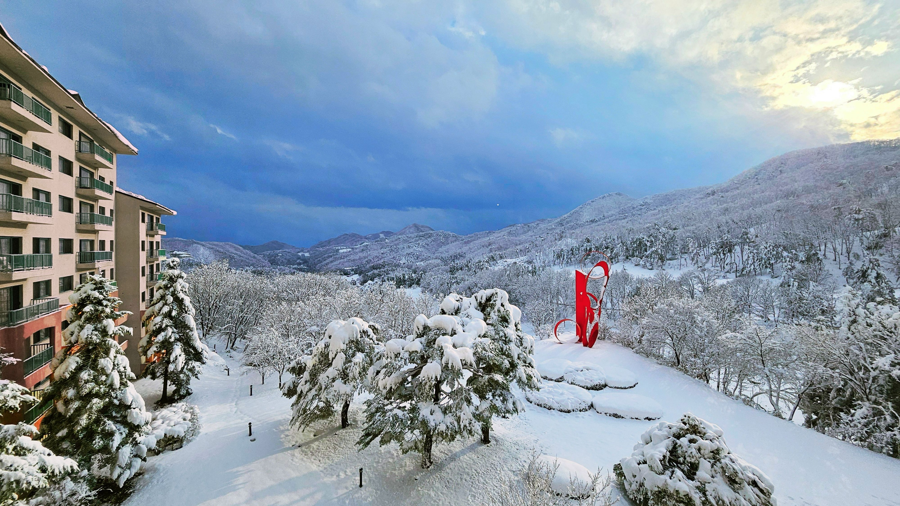白雪覆蓋的橡樹谷度假村和日落下的紅色雕塑——韓國群山中寧靜的江原道冬日風光。 白雪覆蓋的橡樹谷度假村和日落下的紅色雕塑——韓國群山中寧靜的江原道冬日風光。