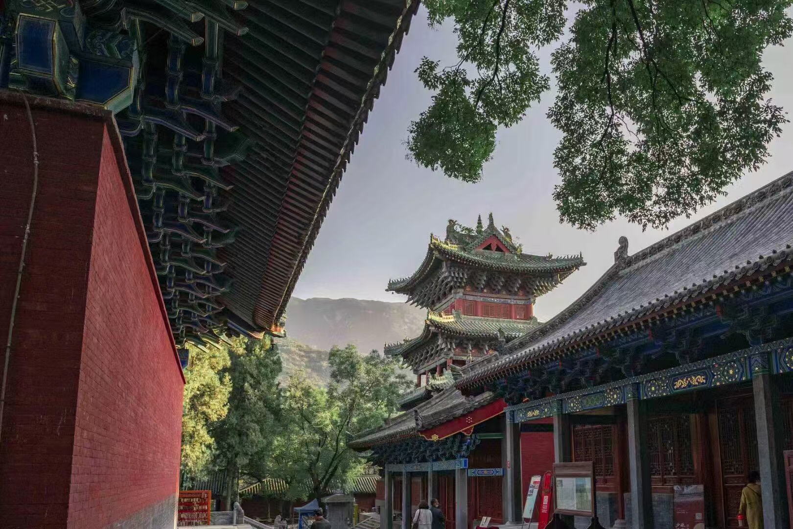 寺院縱深景緻:紅牆與青藍斗拱勾勒前景,中景樓閣飛簷翹角、紅柱綠瓦,背景是連綿青山,層次分明,盡顯寺院藏於山林的清幽意境 寺院縱深景緻:紅牆與青藍斗拱勾勒前景,中景樓閣飛簷翹角、紅柱綠瓦,背景是連綿青山,層次分明,盡顯寺院藏於山林的清幽意境