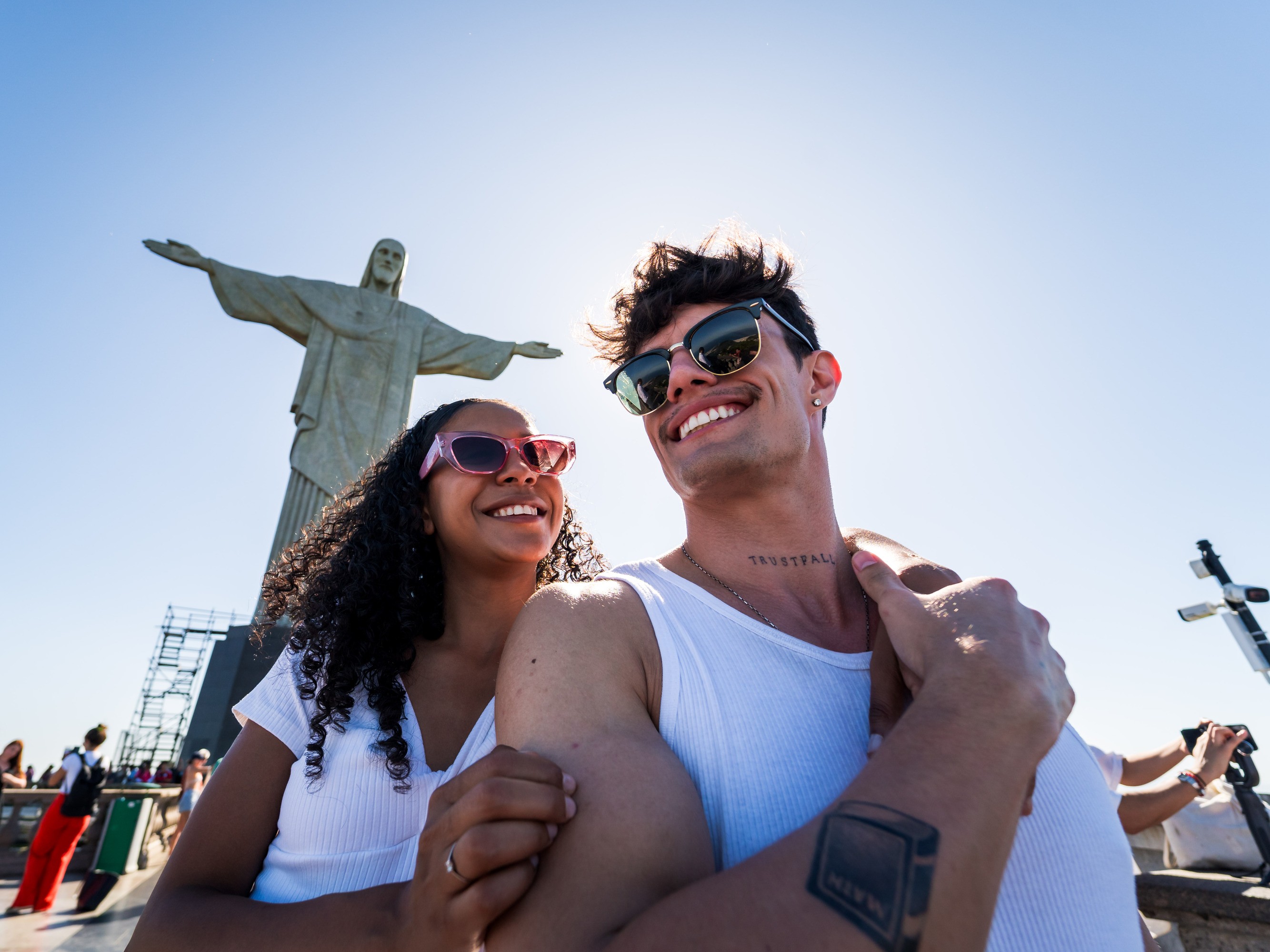 Visitors smiling brightly in front of the iconic Christ the Redeemer on Corcovado