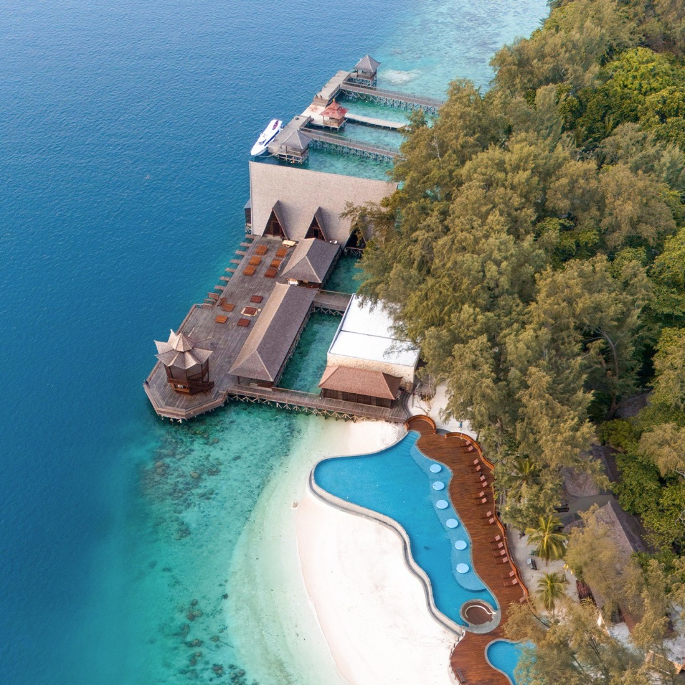 寧靜的水上別墅，配有私人泳池，依偎在熱帶島嶼天堂的蔥鬱海岸線上