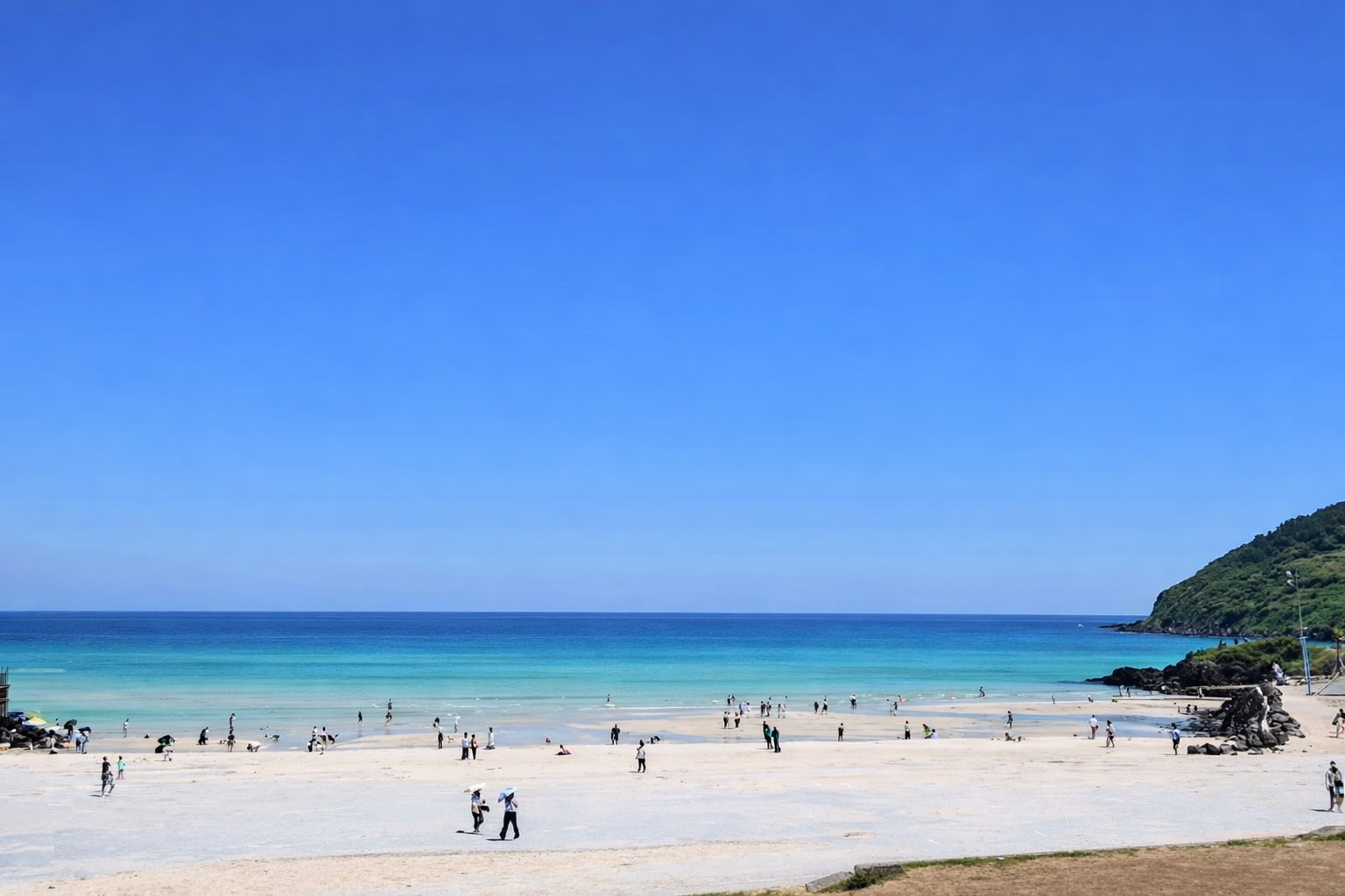 Discover the crystal-clear waters of Hamdeok Beach, Jeju.
