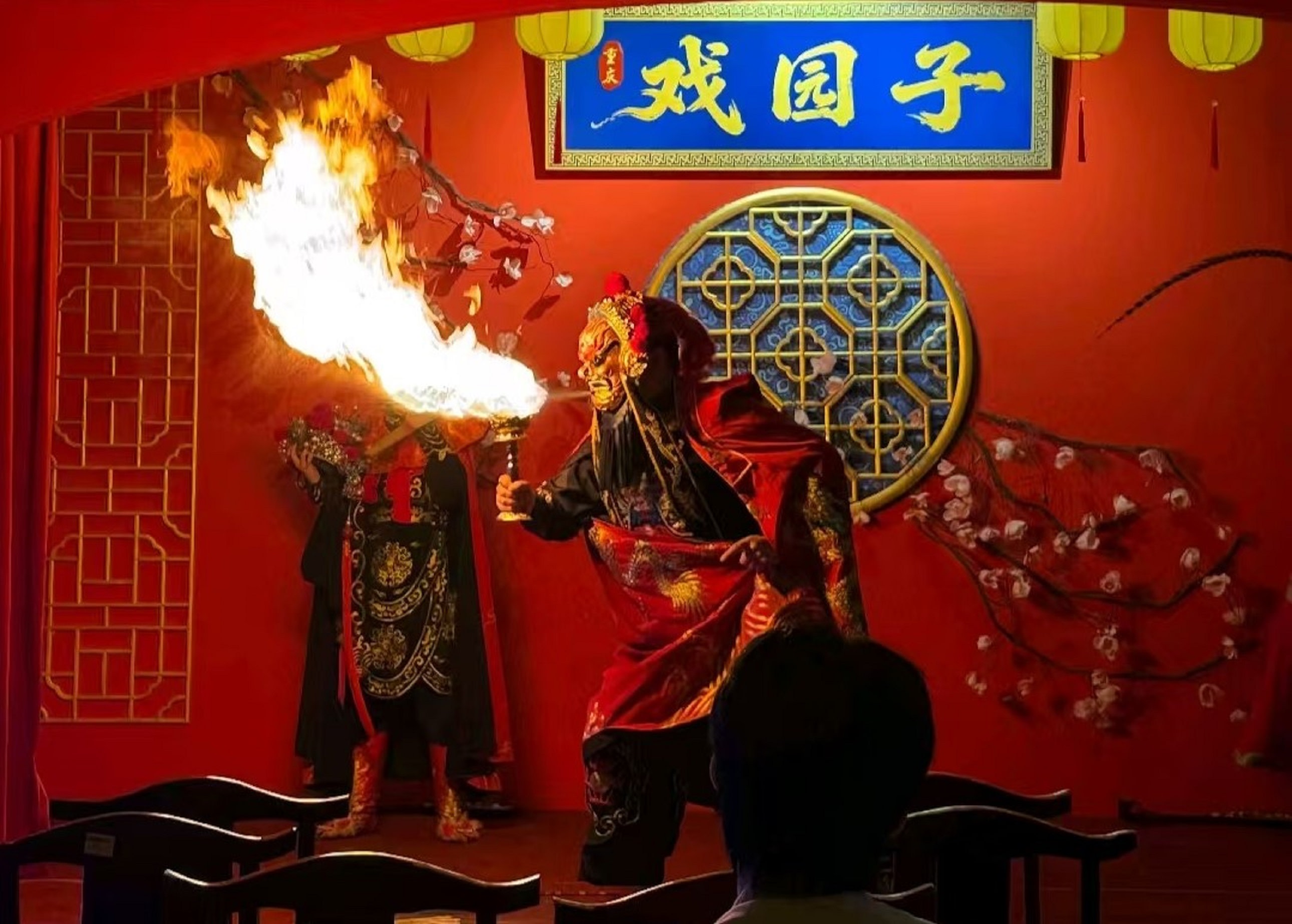 硃紅戲臺映著鎏金窗欞,梅花枝椏斜斜舒展,暖黃燈籠懸於穹頂,將古色古香的戲園暈染出溫柔光暈 硃紅戲臺映著鎏金窗欞,梅花枝椏斜斜舒展,暖黃燈籠懸於穹頂,將古色古香的戲園暈染出溫柔光暈