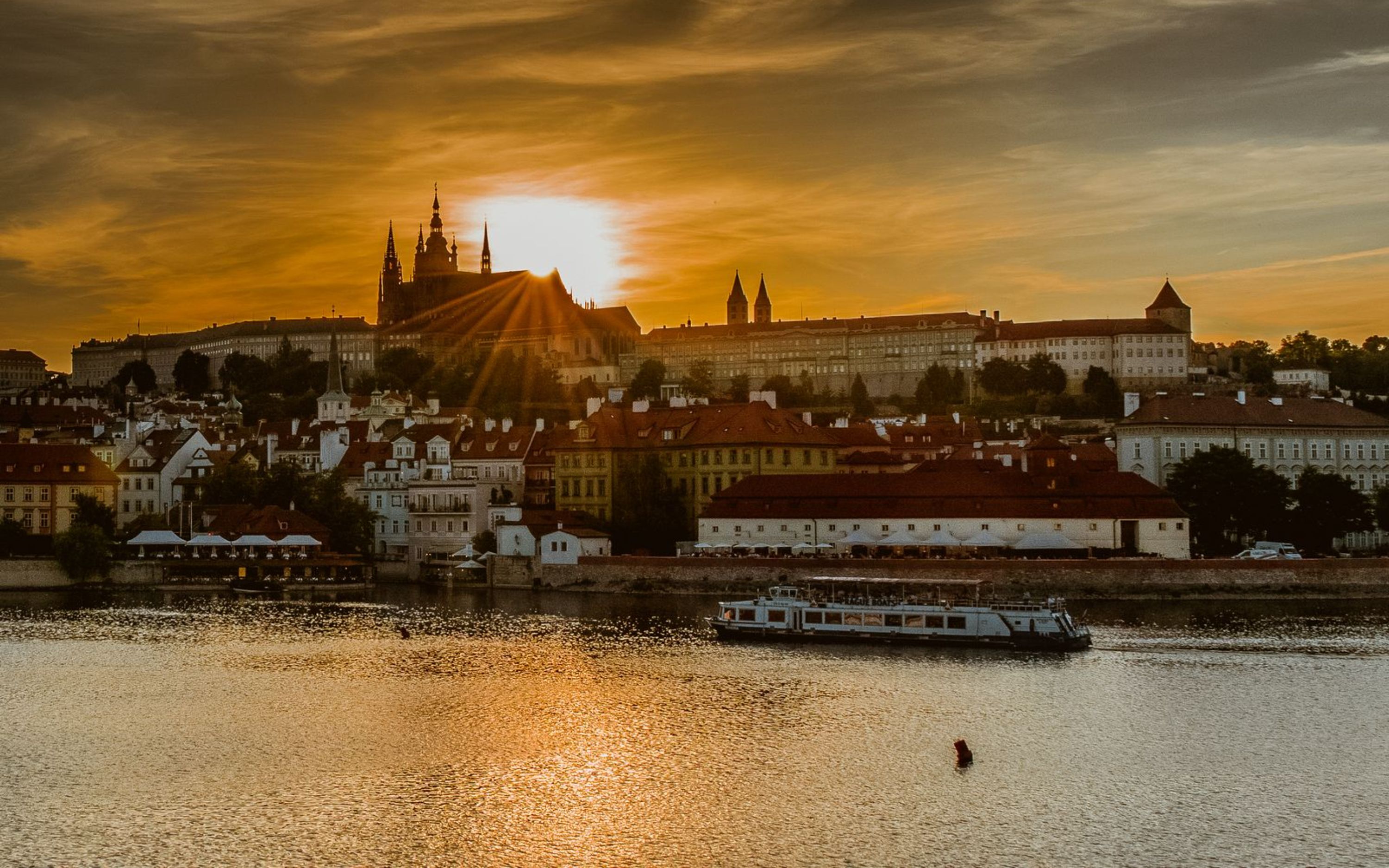在甲板上舒適地欣賞布拉格城堡上空壯觀的金色日落