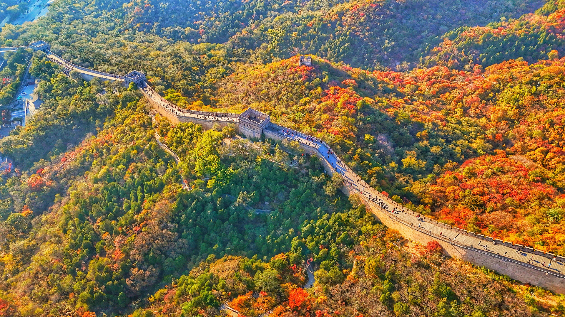 秋日裡，以斑斕秋葉為前景，古老的長城敵樓在層巒疊嶂的黛色遠山前巍然矗立，古今交融，靜謐而雄渾。