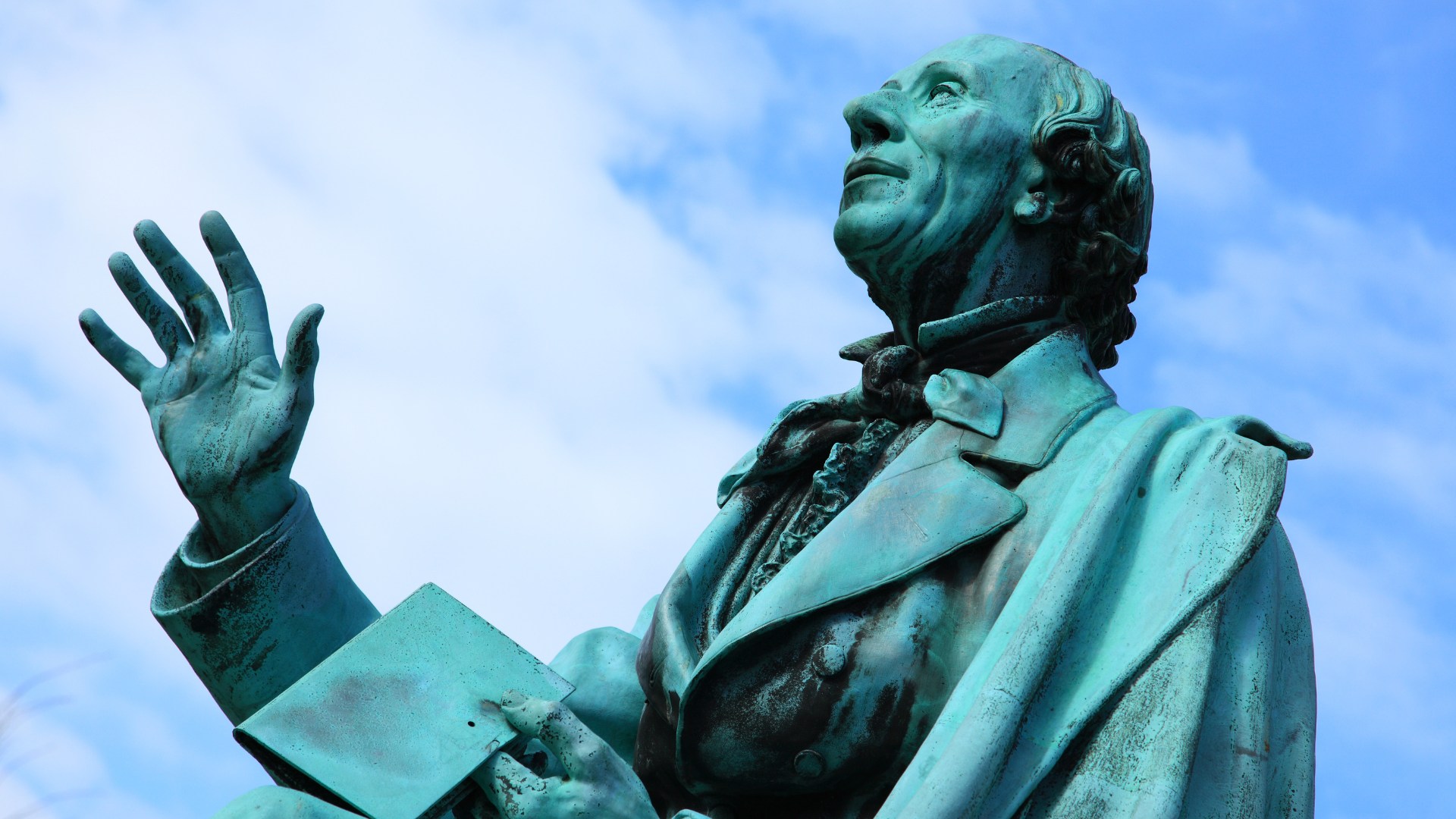 哥本哈根的漢斯・克里斯汀・安徒生雕像 (Hans Christian Andersen Statue) 旨在向這位深受喜愛的作家致敬，捕捉他永恆的傳奇，並邀請遊客一同回味那迷倒一代又一代人的迷人童話故事。