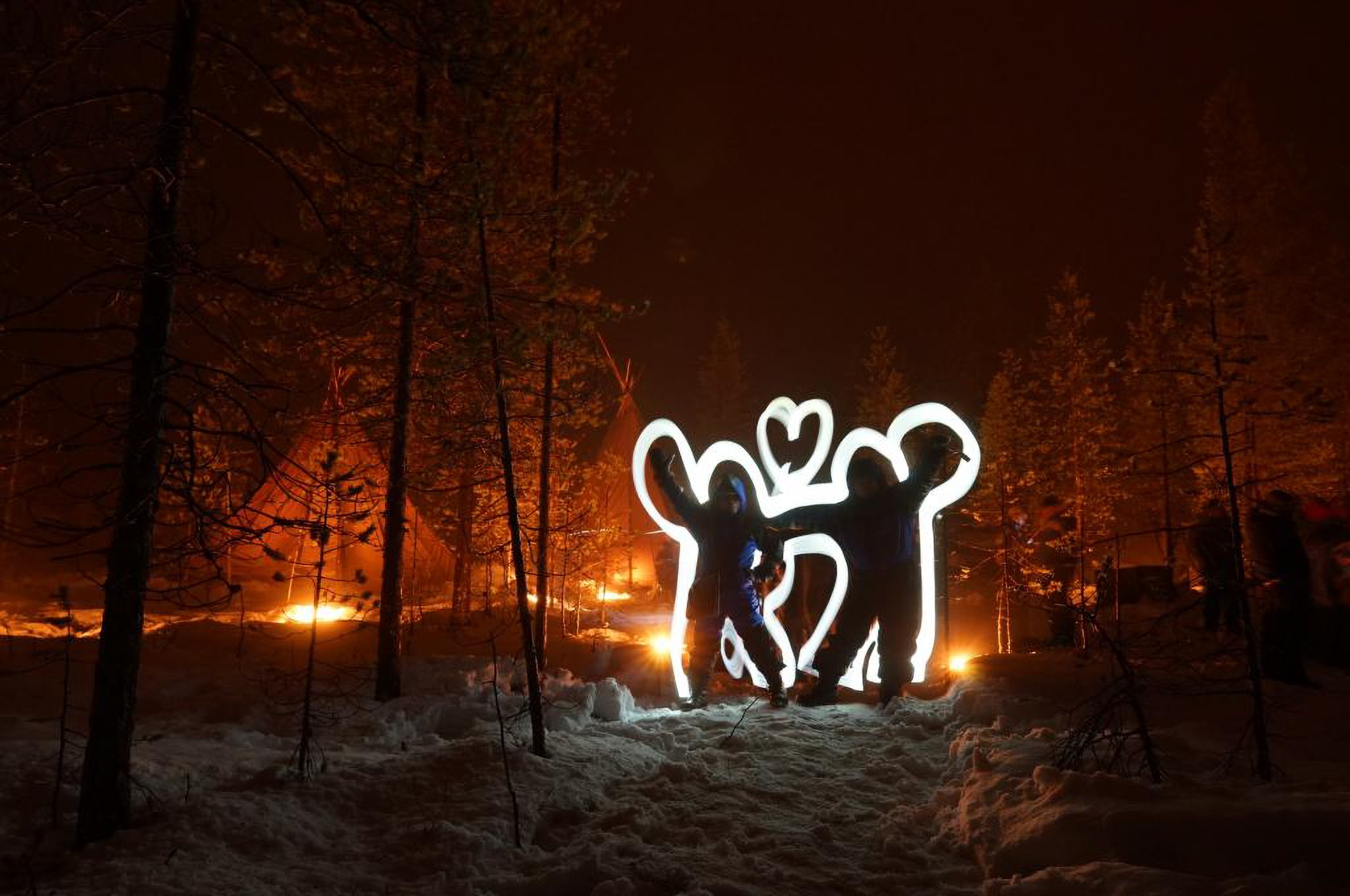 Creative light art illuminates the snowy forest, adding fun and magic to the Arctic adventure