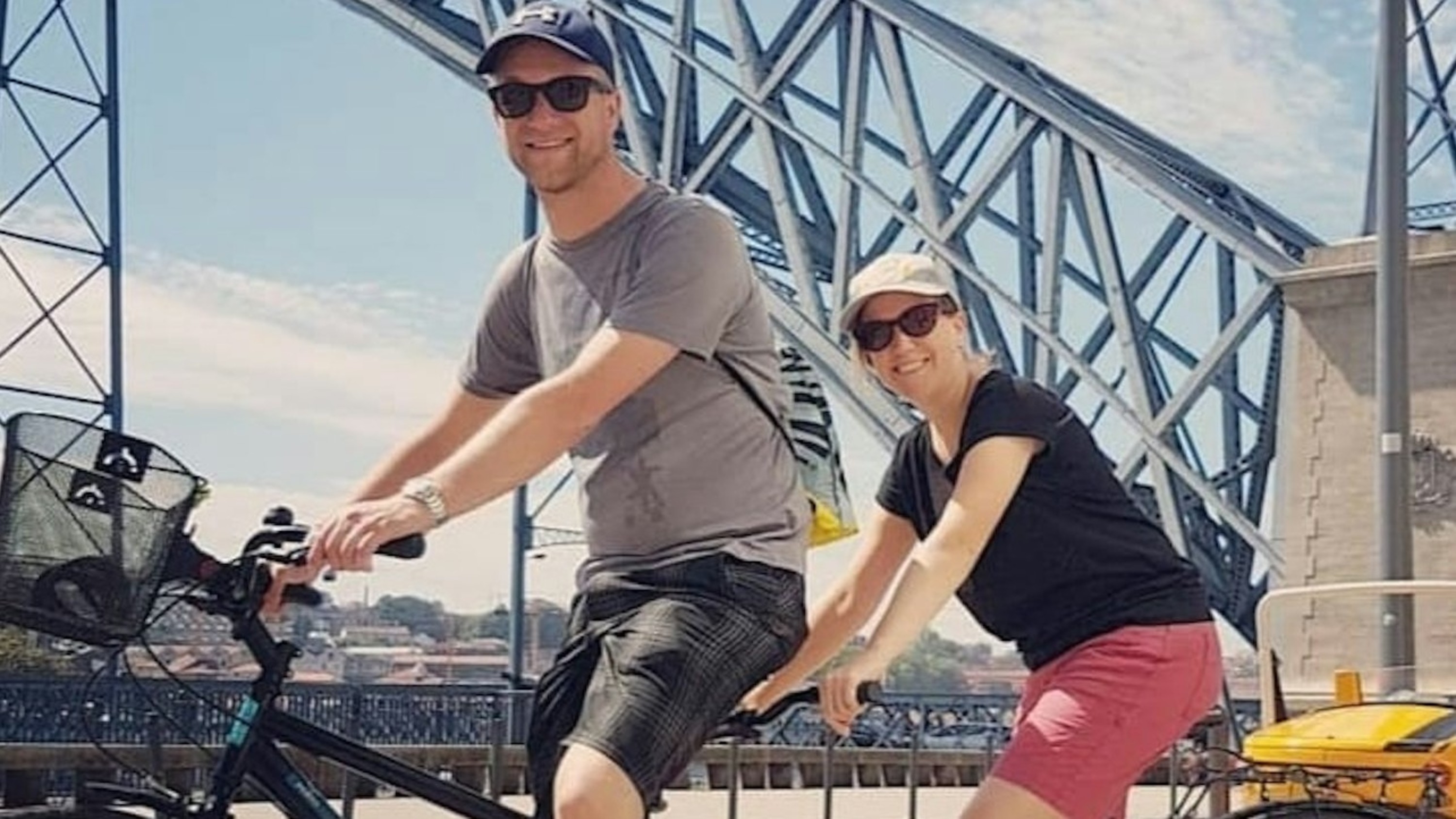 Cyclist riding with Porto’s iconic bridge beautifully framed in the scenic background
